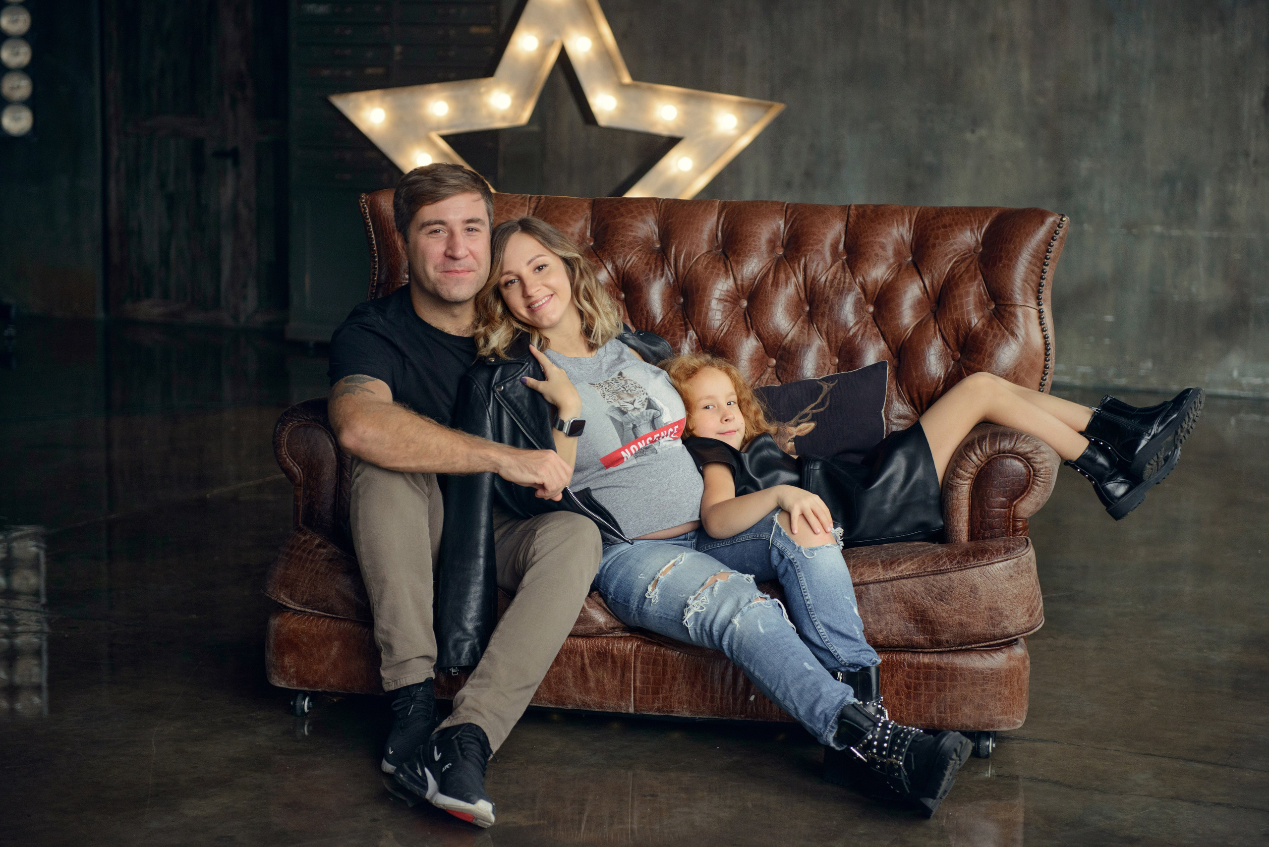 Family photo shoot with a pregnant woman in a loft studio, rock and roll style