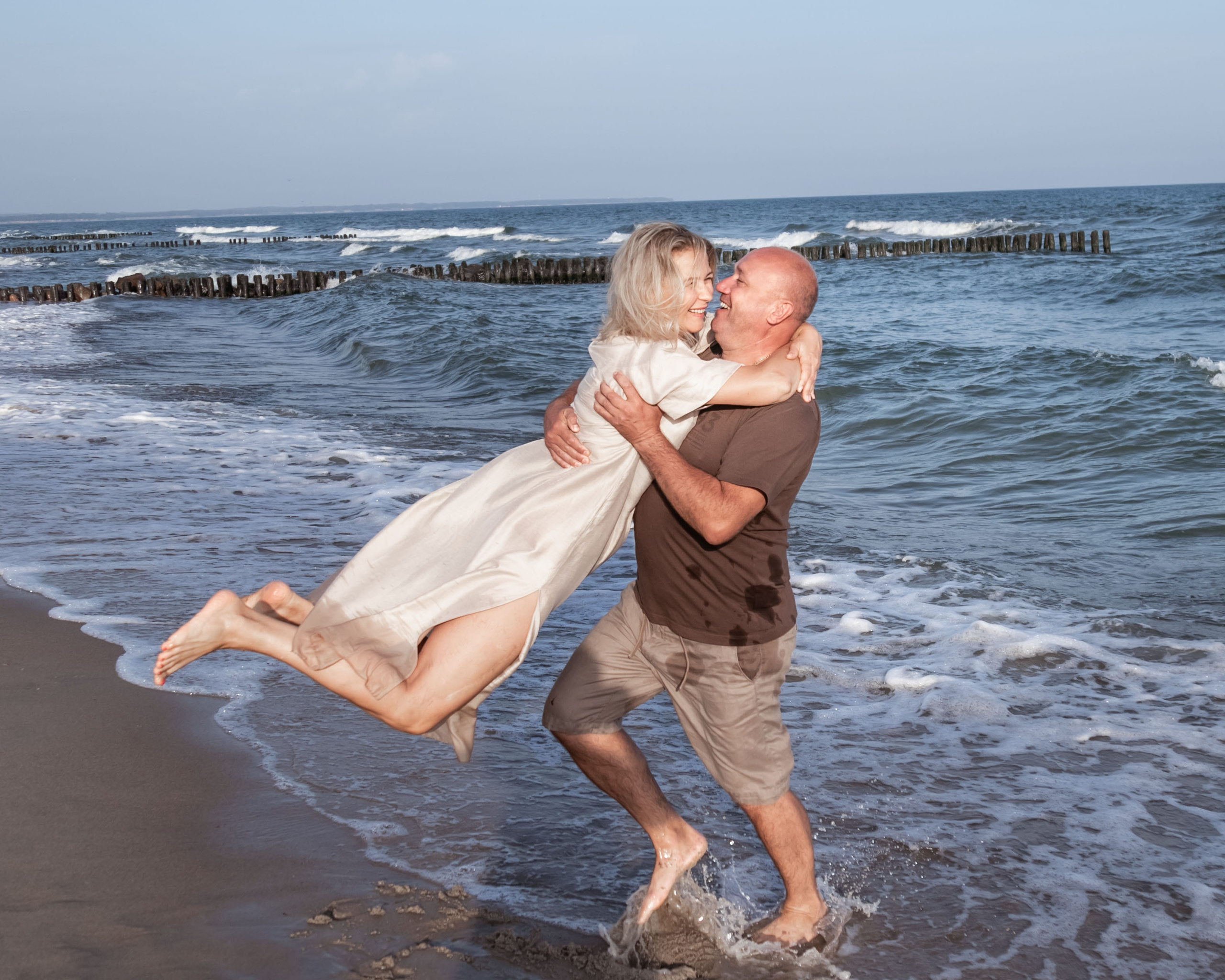 муж и жена кружатся в танце у моря