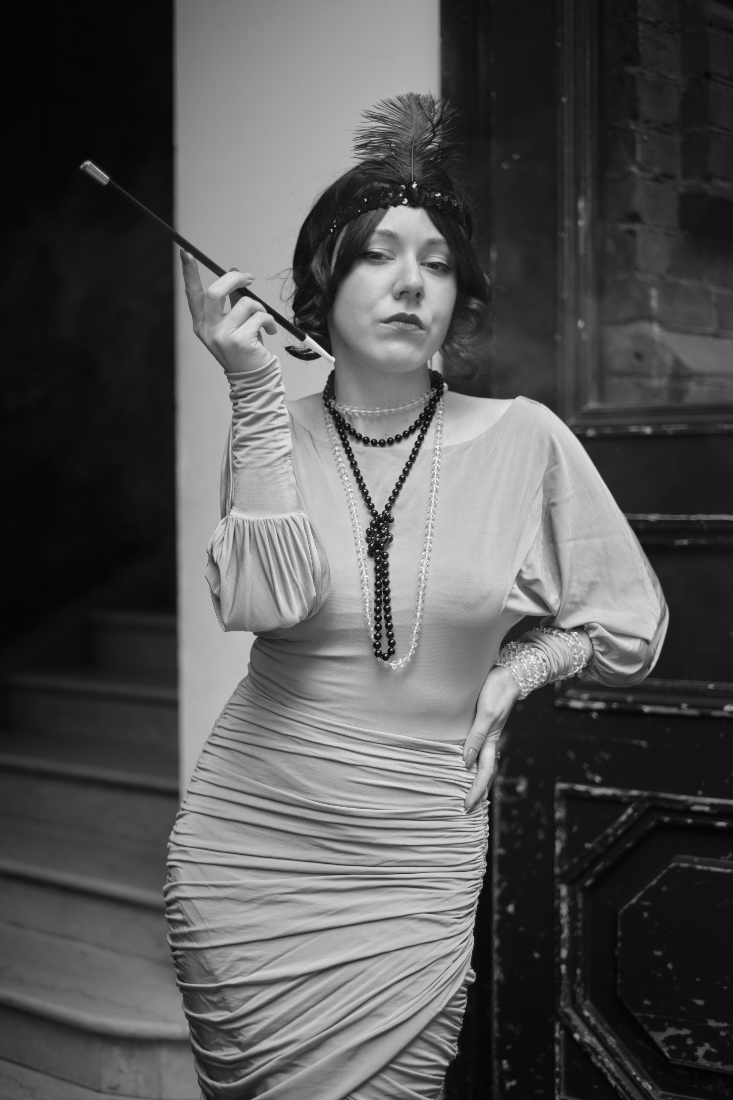 Девушка в костюме кабаре курит сигарету на мундштуке 