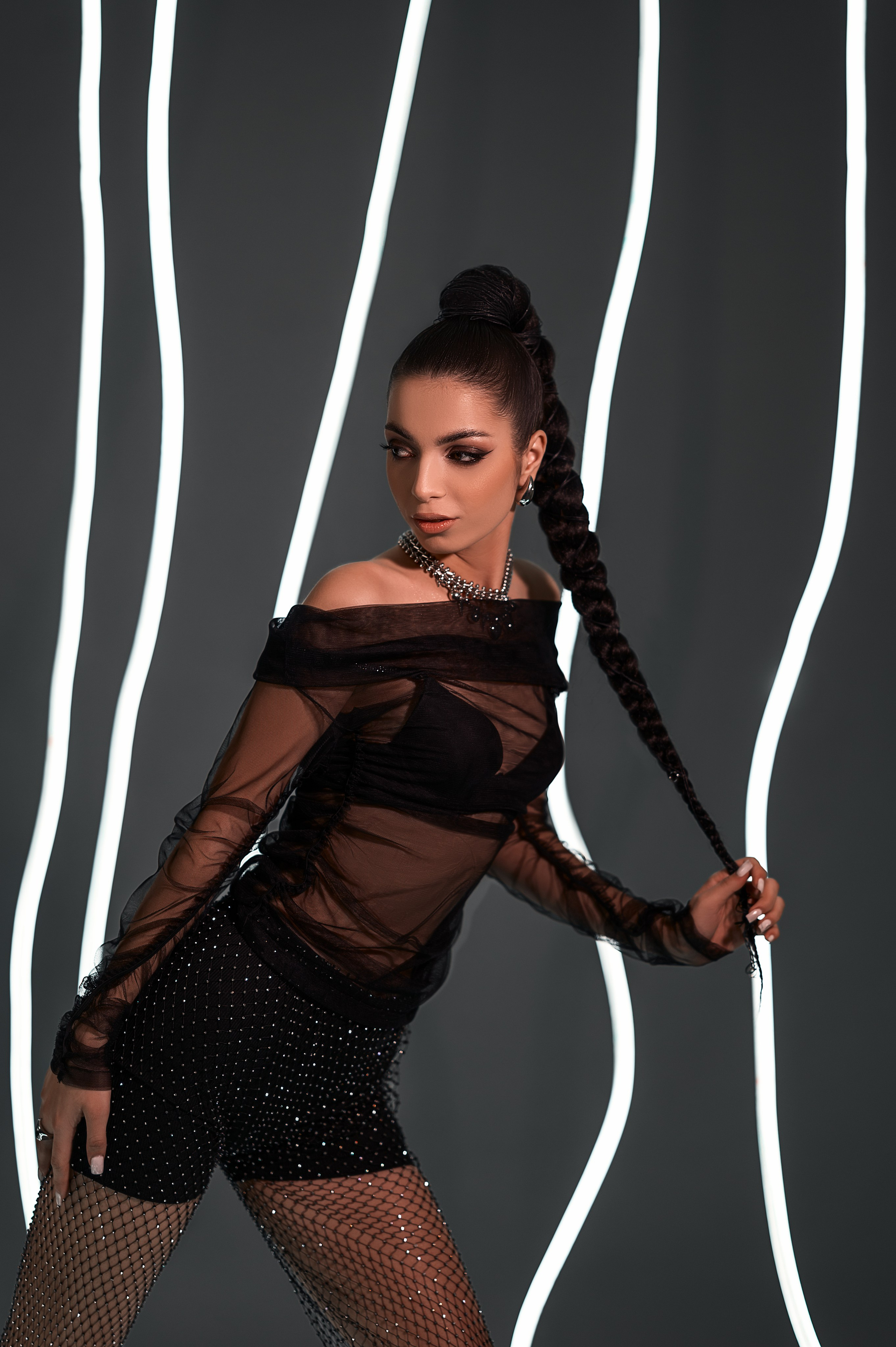 Фотосессия от Елизаветы Жуйковой: девушка в студии. Чёрная одежда, серый фон, неоновая подсветка — сдержанный образ с яркими акцентами.