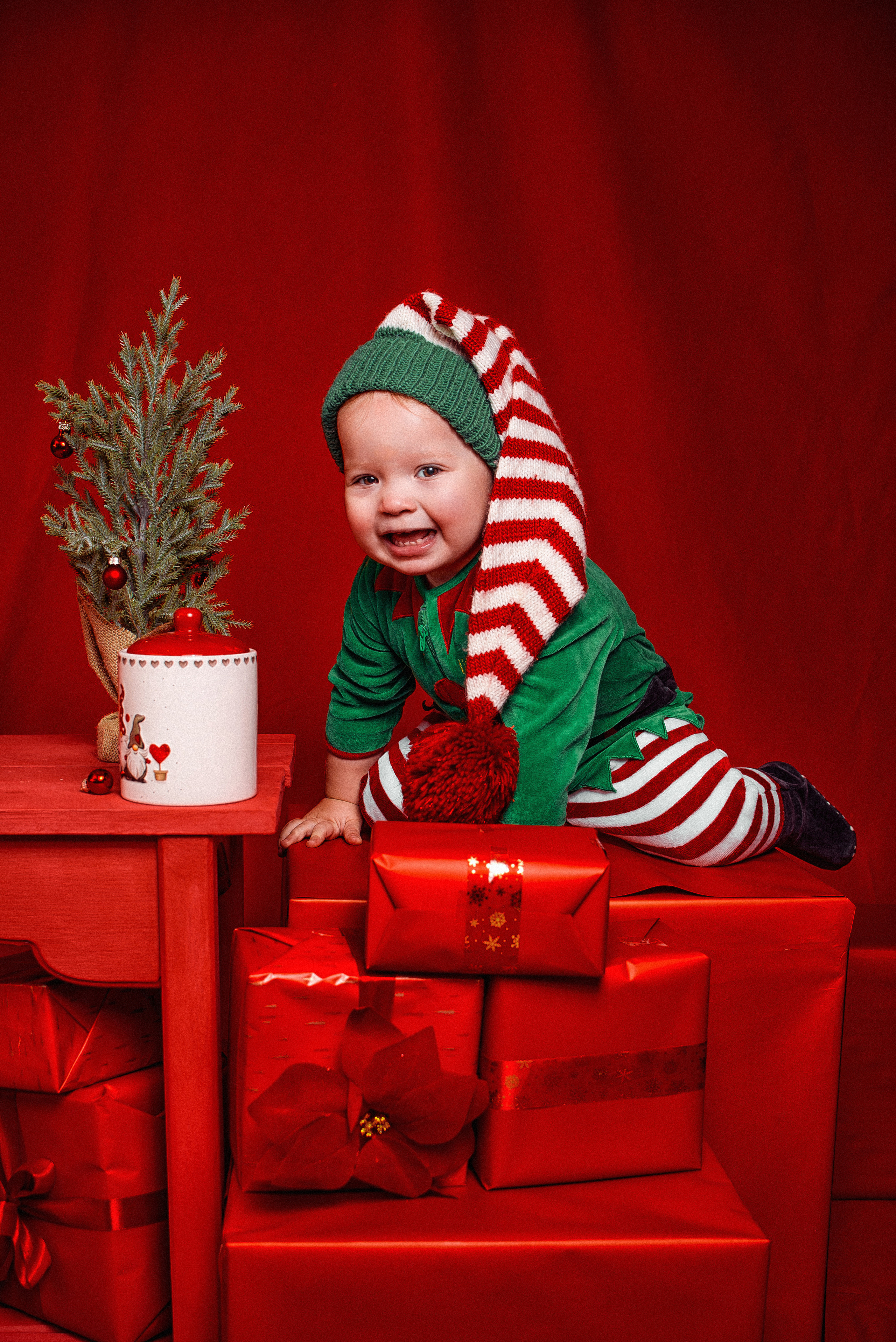 ребёнок в костюме на новогодней студийной фотосессии в красном цвете в сочи в фотостудия в Кудепсте