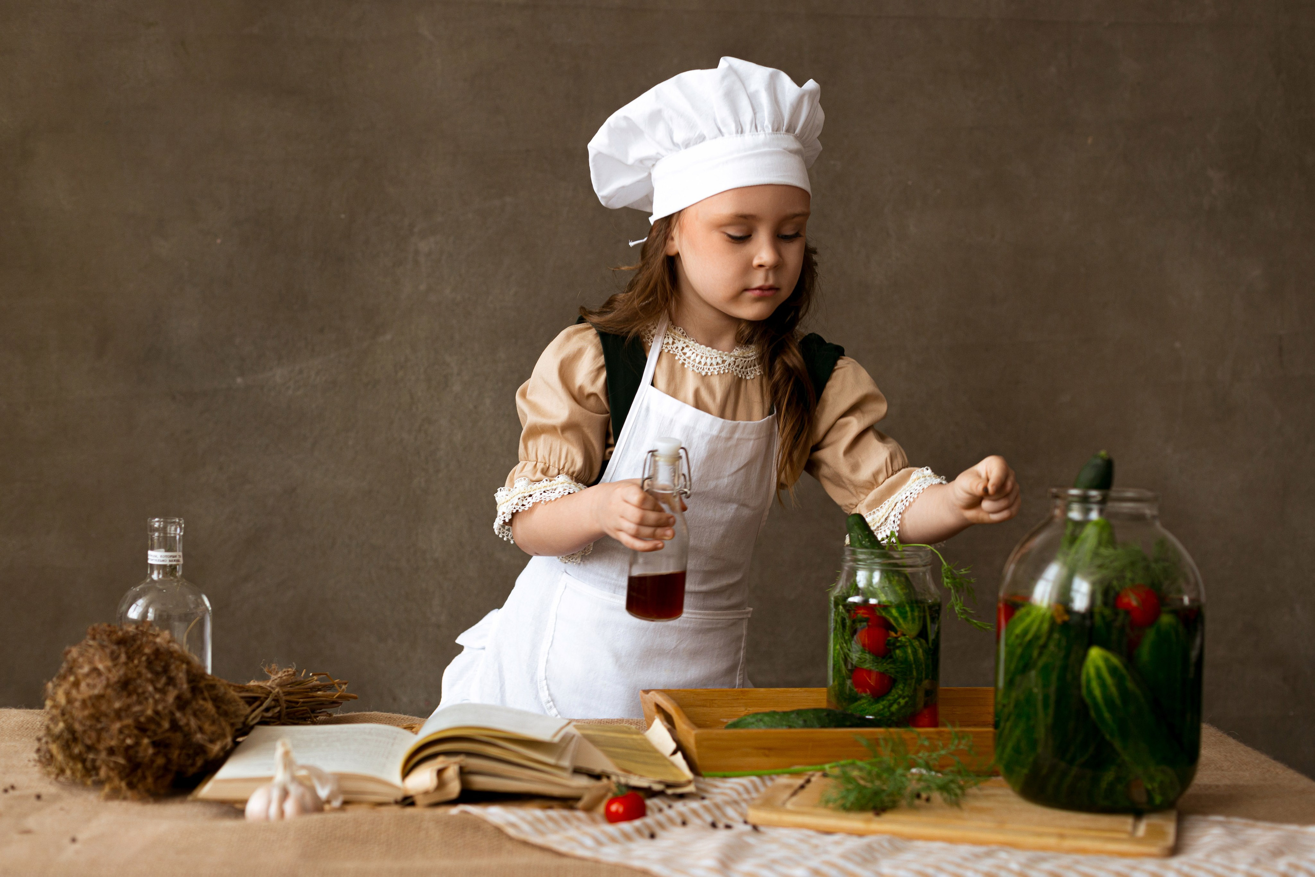 Девочка в поварском колпаке готовит