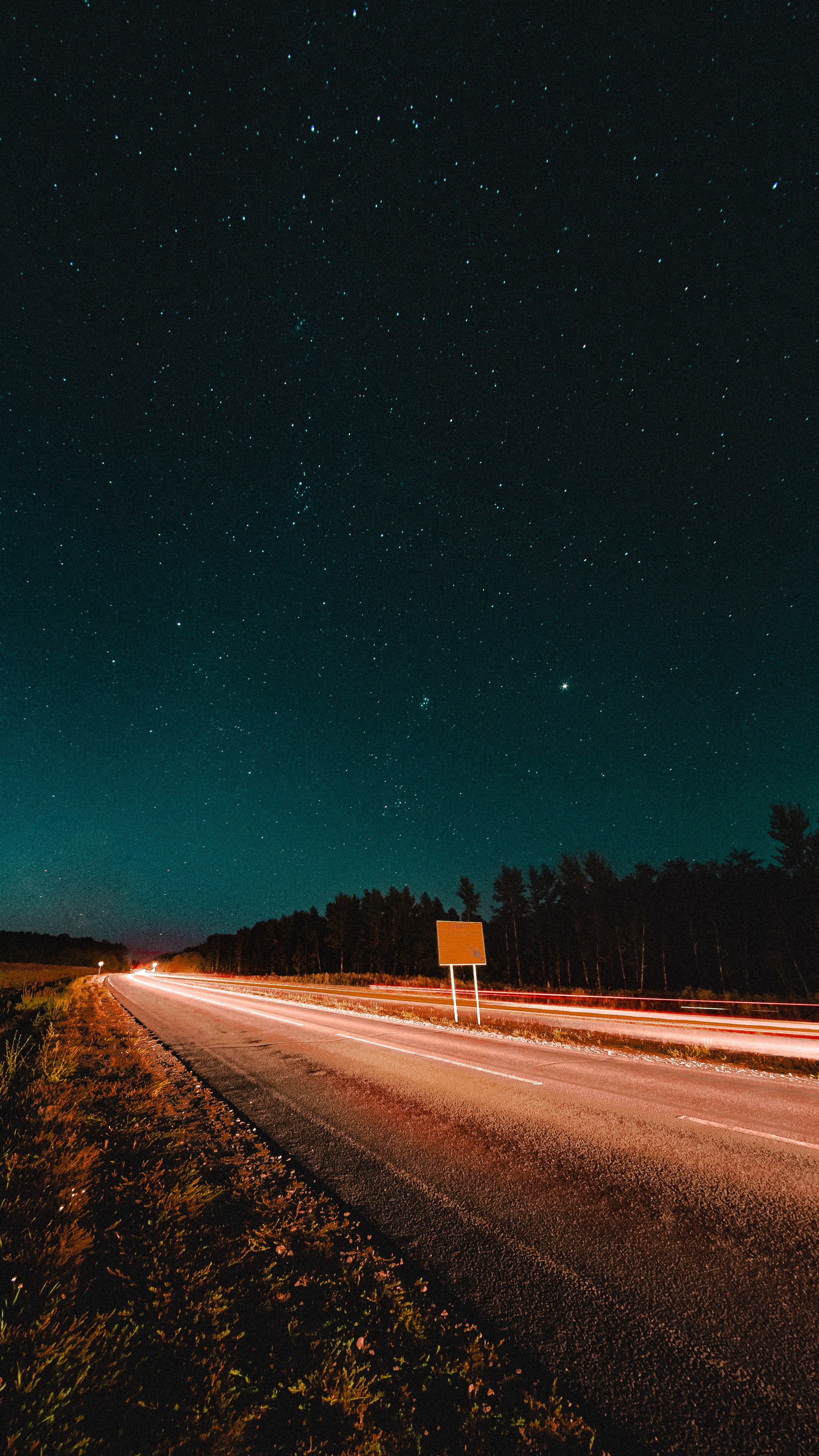 Звёздный пейзаж на фоне дороги и проезжающей машины
