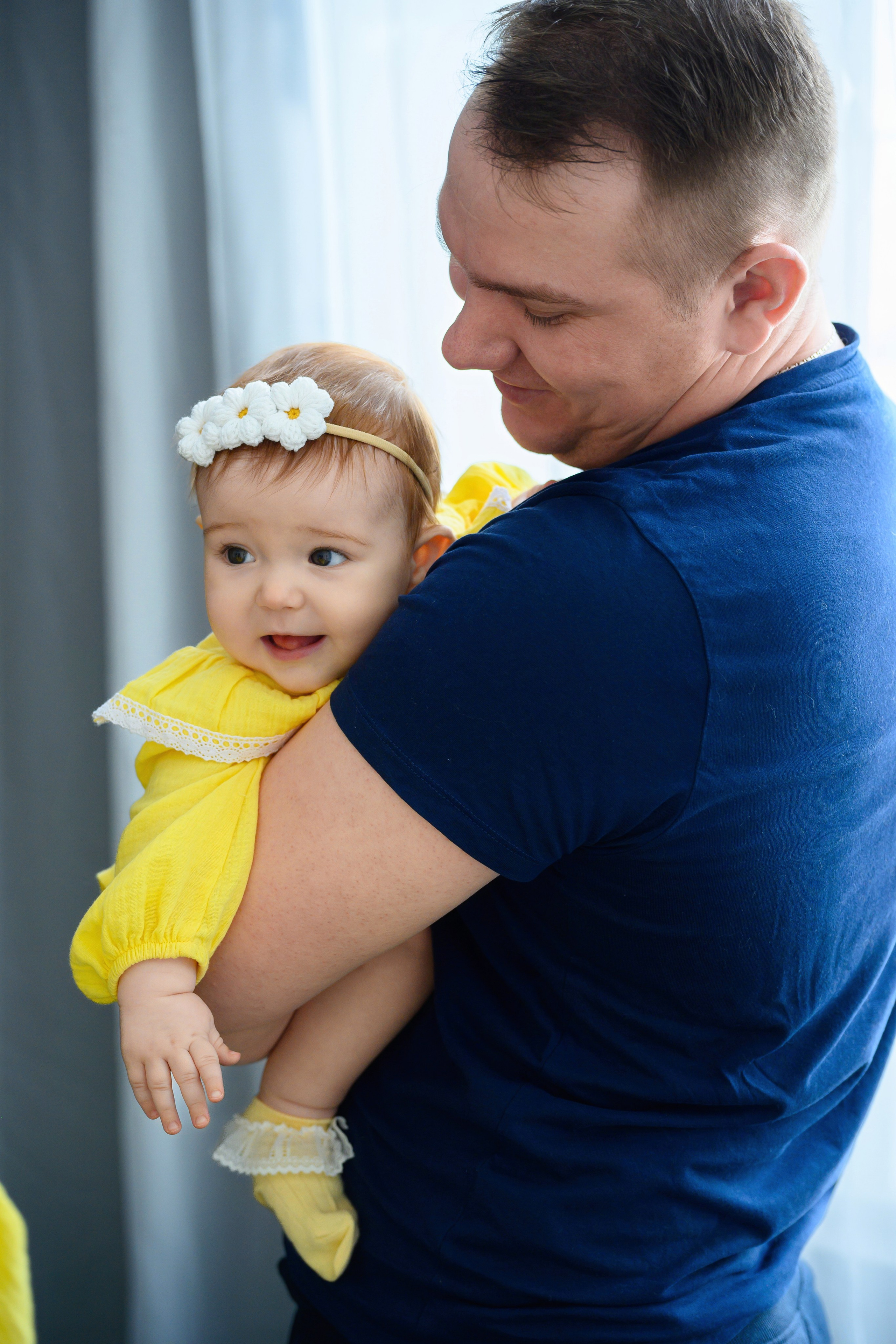 Малышка на руках у папы смотрит на маму