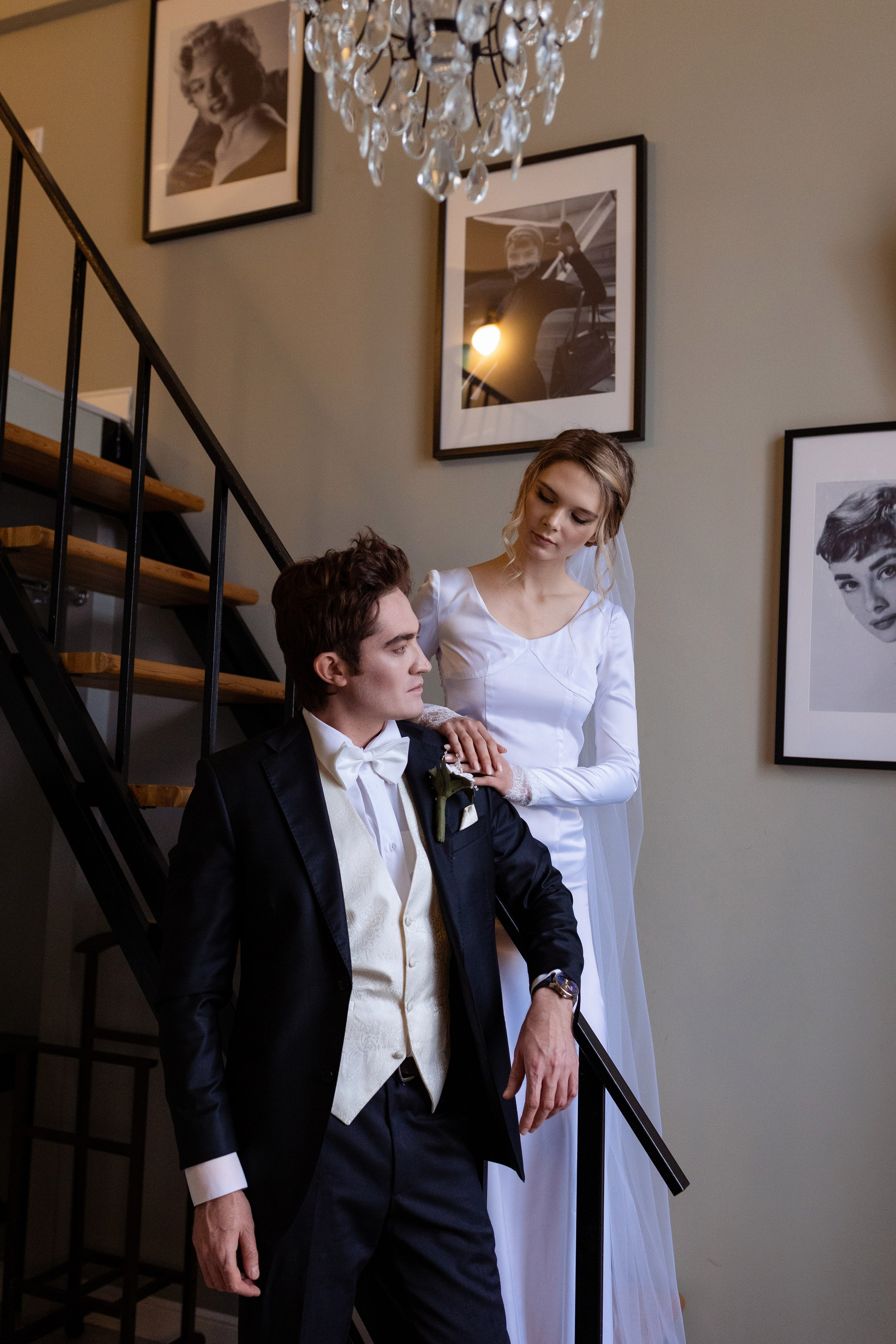 Жених стоит у лестницы, рядом на лестнице стоит невеста.