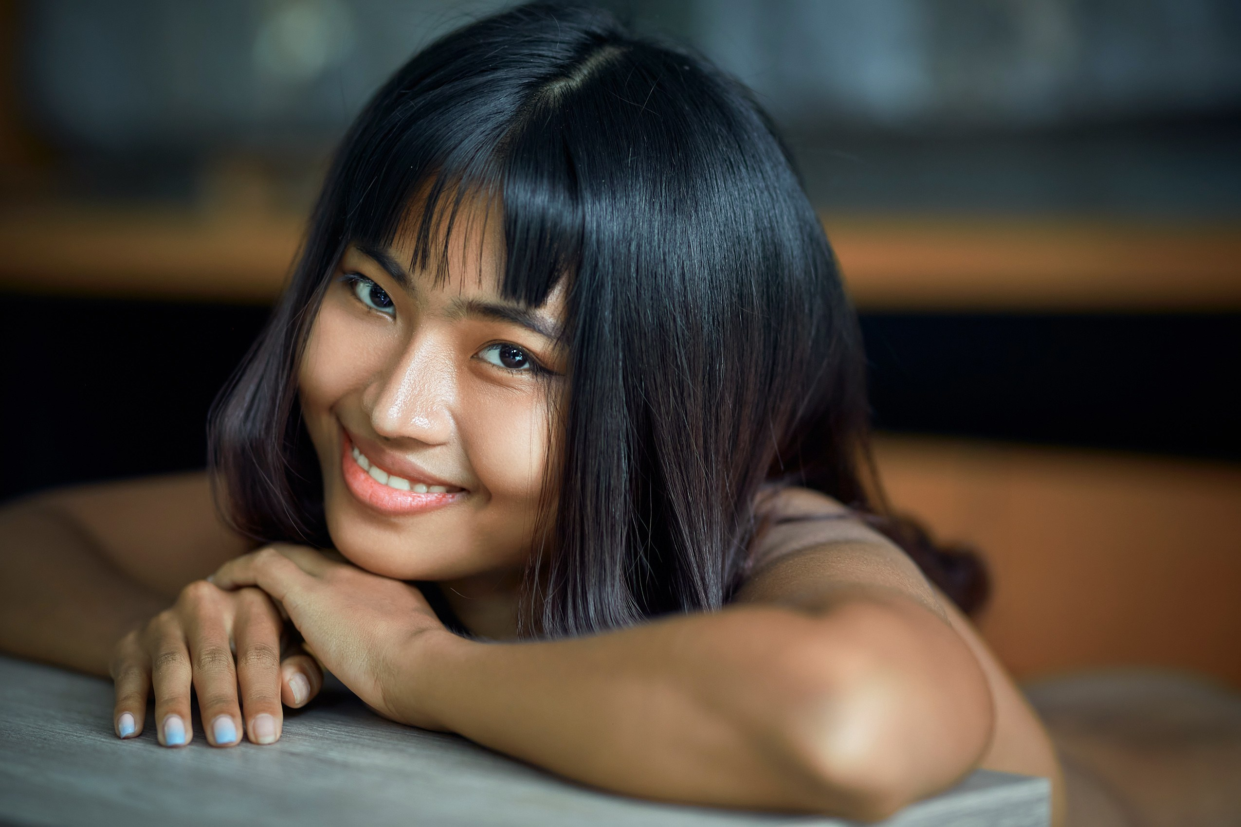 Natural portrait of young Asian woman with soft smile, intimate lifestyle photography in Phu Quoc, Vietnam, warm light indoor photoshoot, authentic feminine beauty, professional portrait photographer