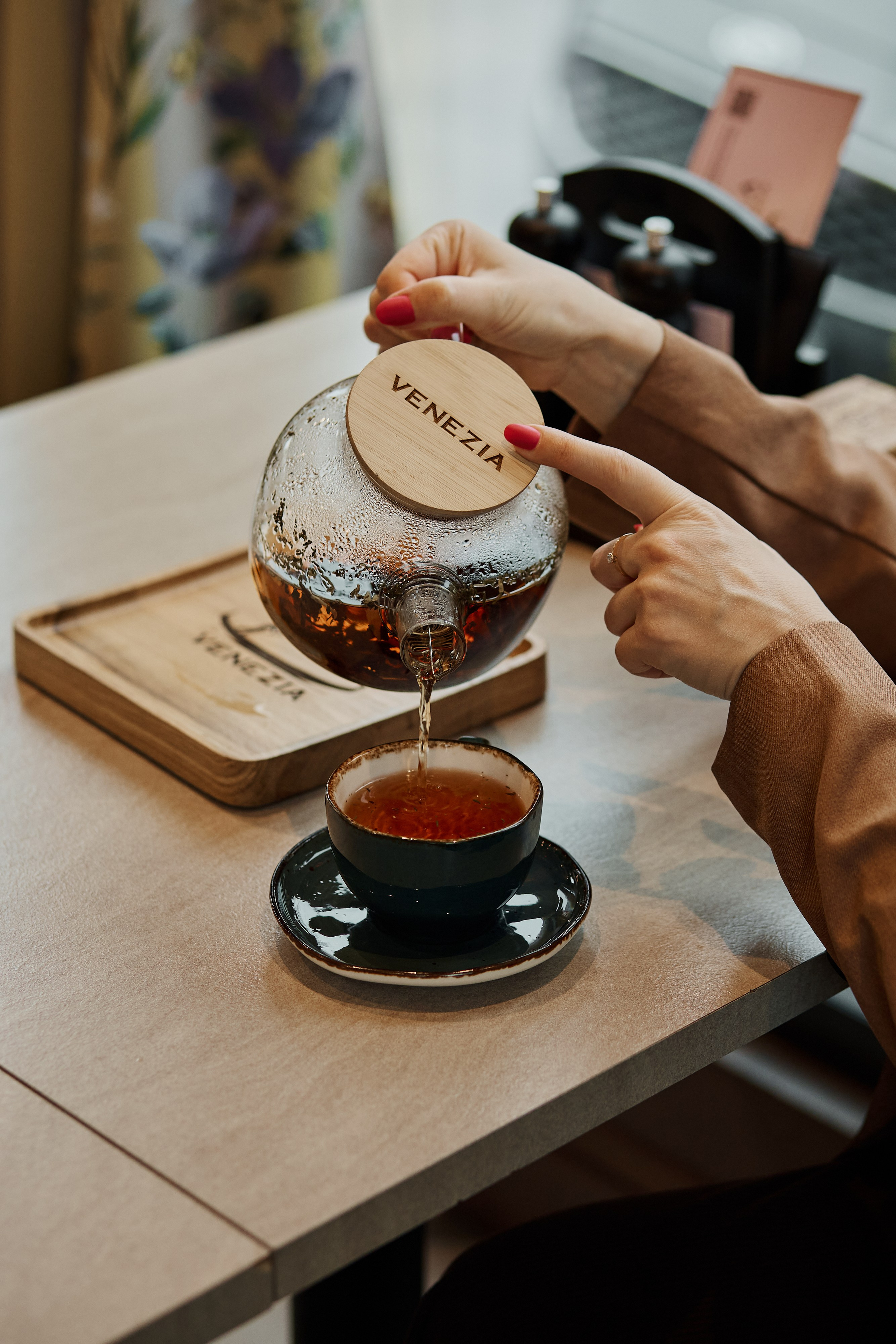 Девушка наливает чай в кружку в кафе