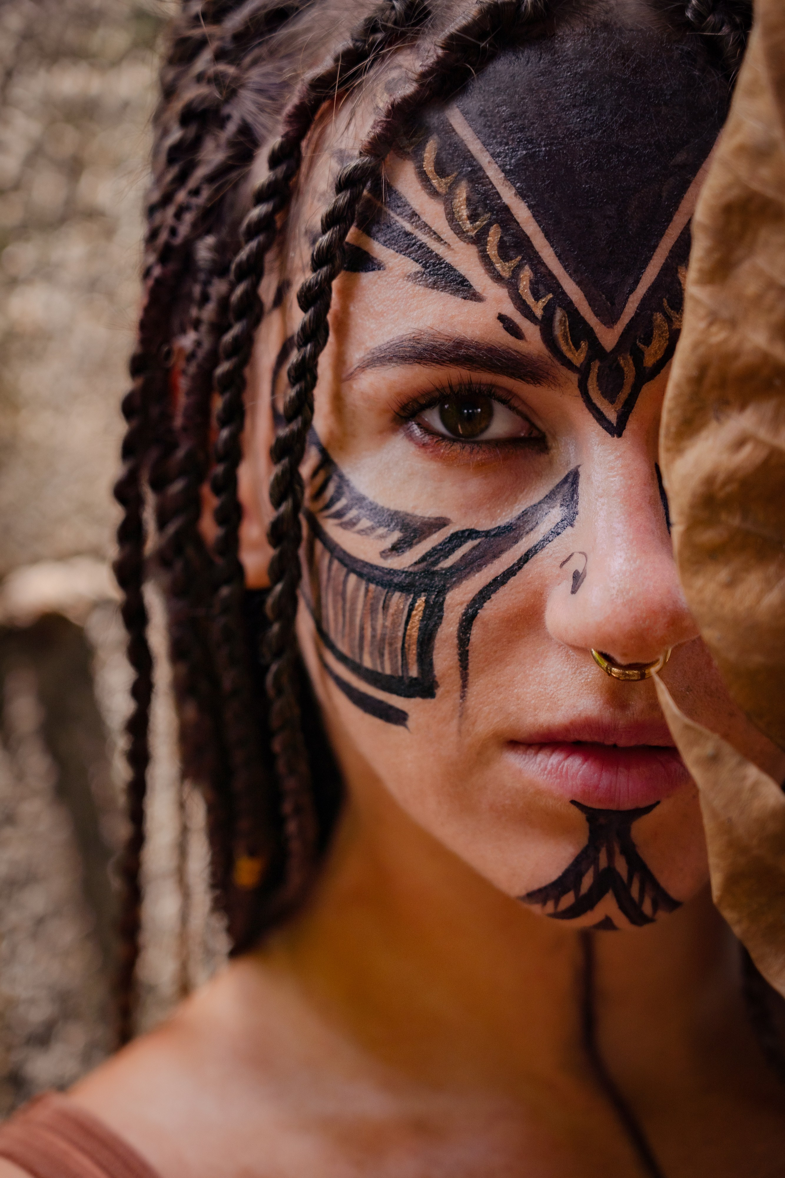 a girl with braids and colorful face paint in the dense jungle