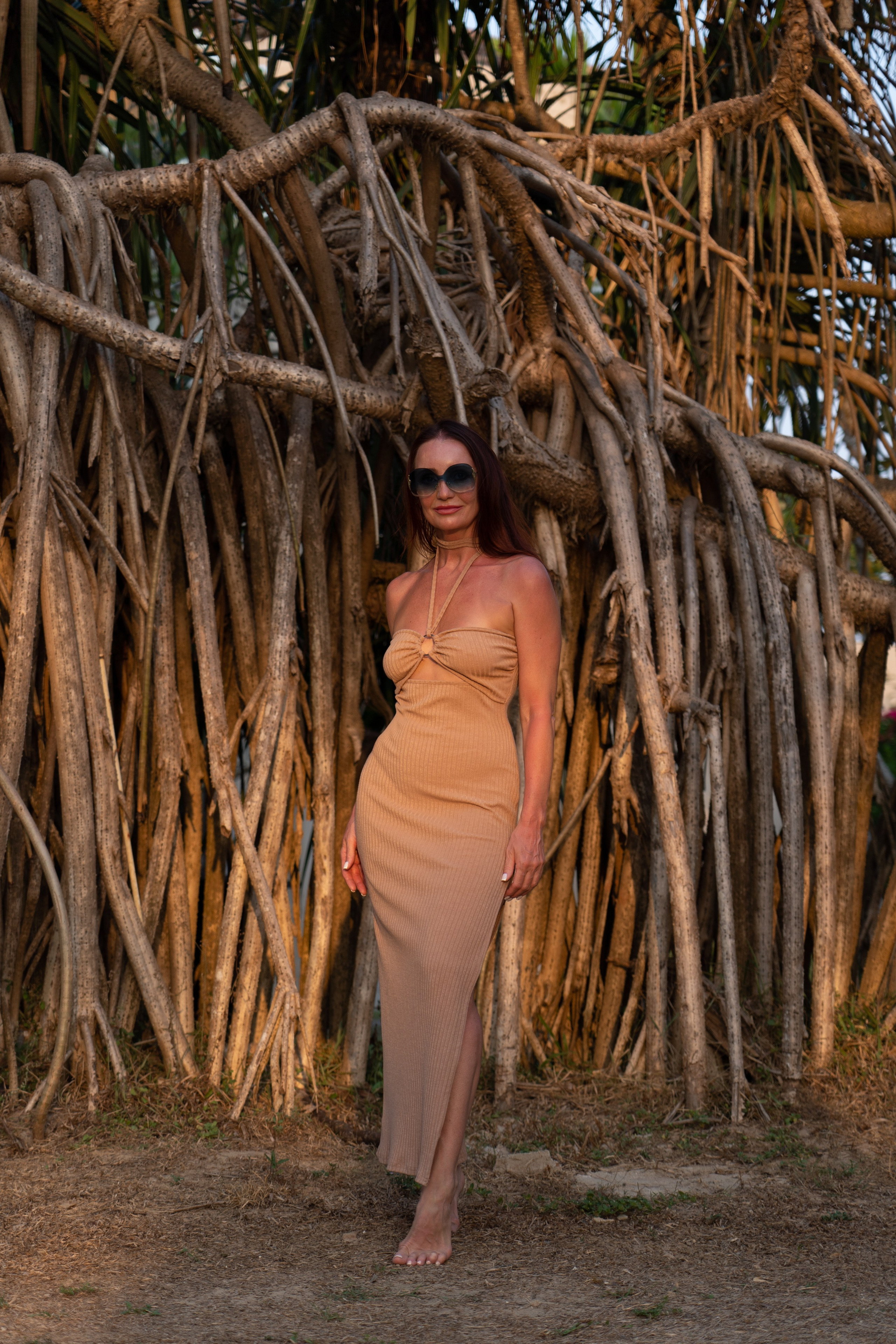a girl in glasses with waves and sand in the background