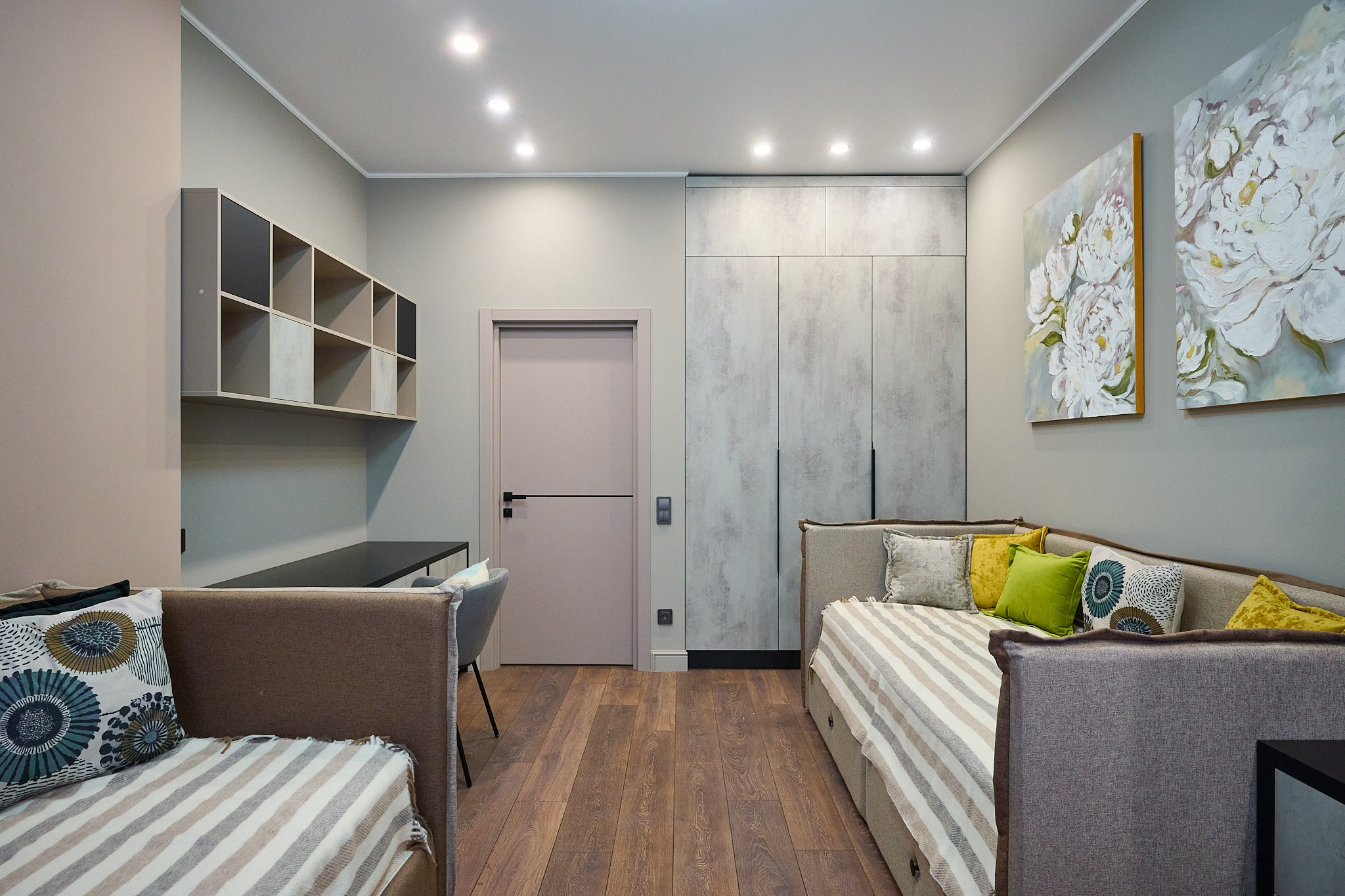 Комната с двумя коричневыми диванами, белыми подушками, серым столом и полками