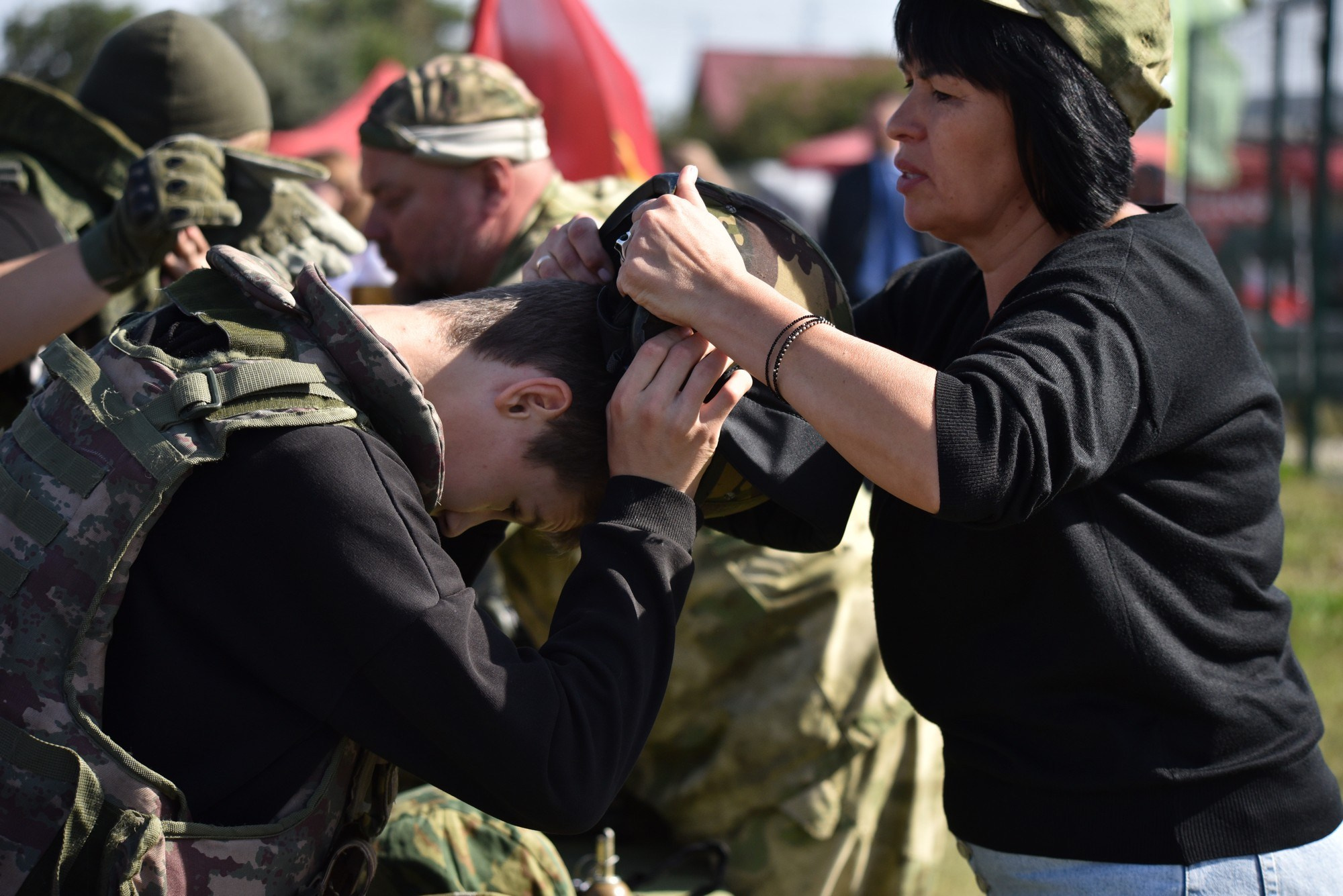 Репортажная съемка.Тренер одевает военную каску мальчику