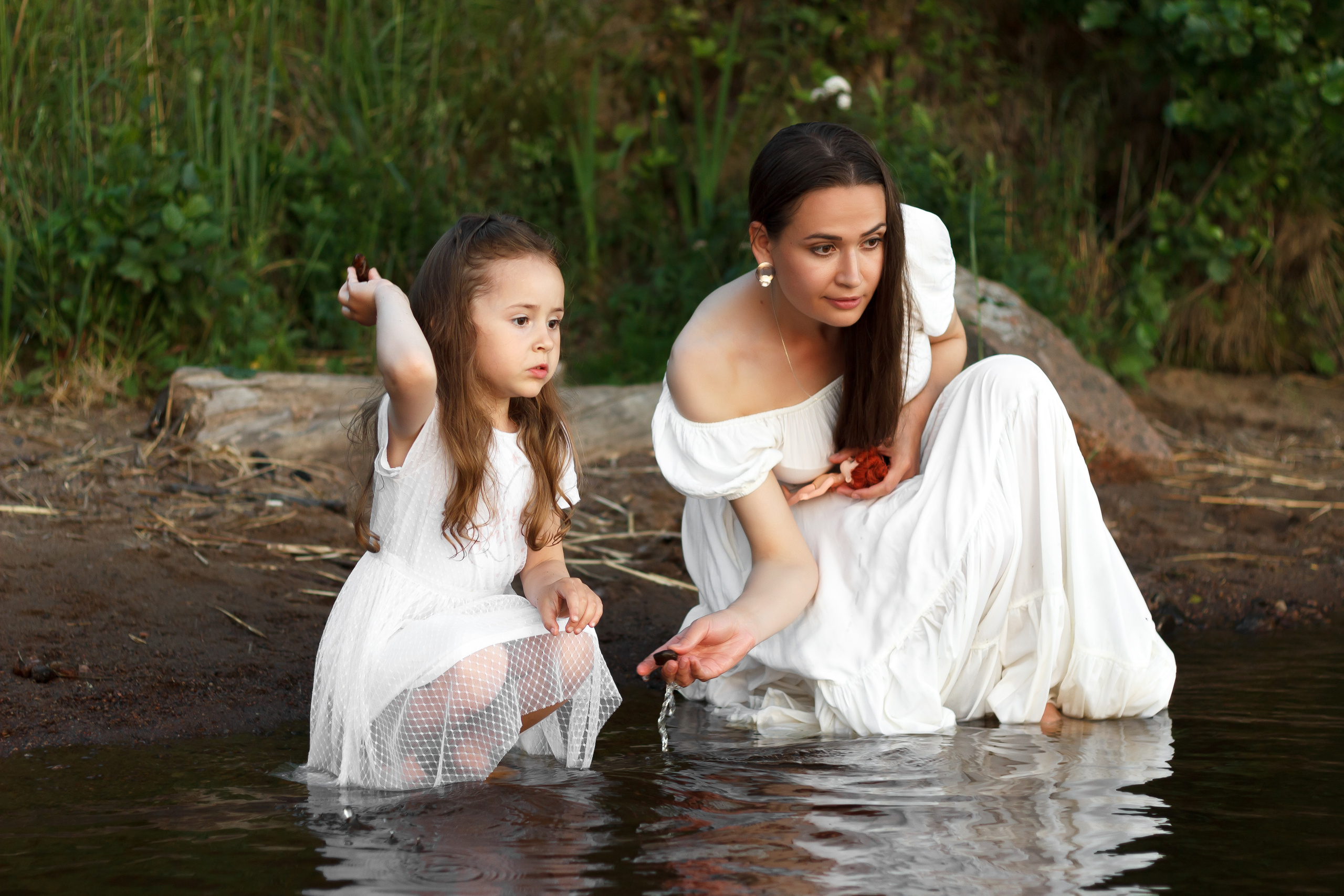 Дочь и мама кормят уток