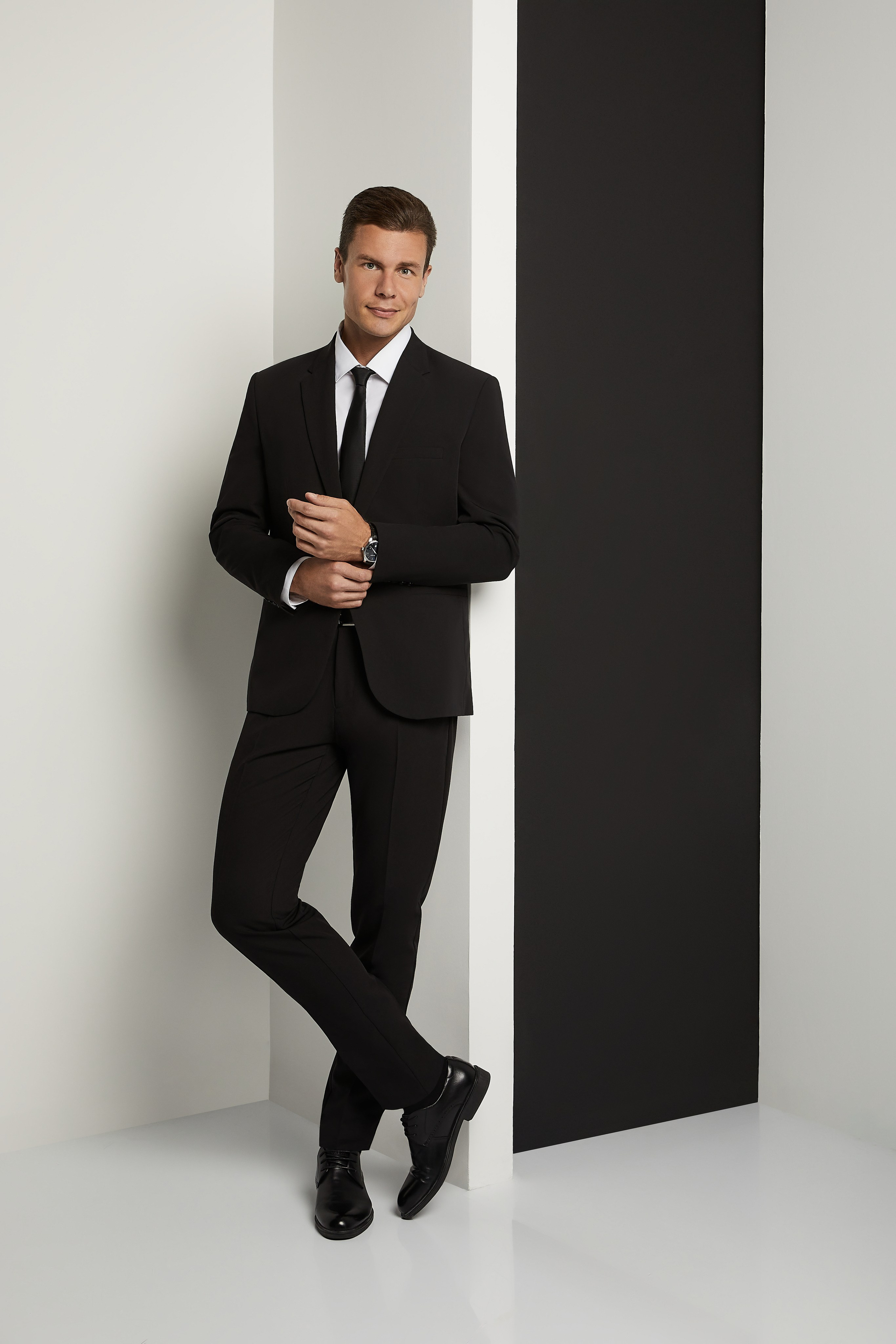 Мужчина модель в классическом черном костюме с галстуком