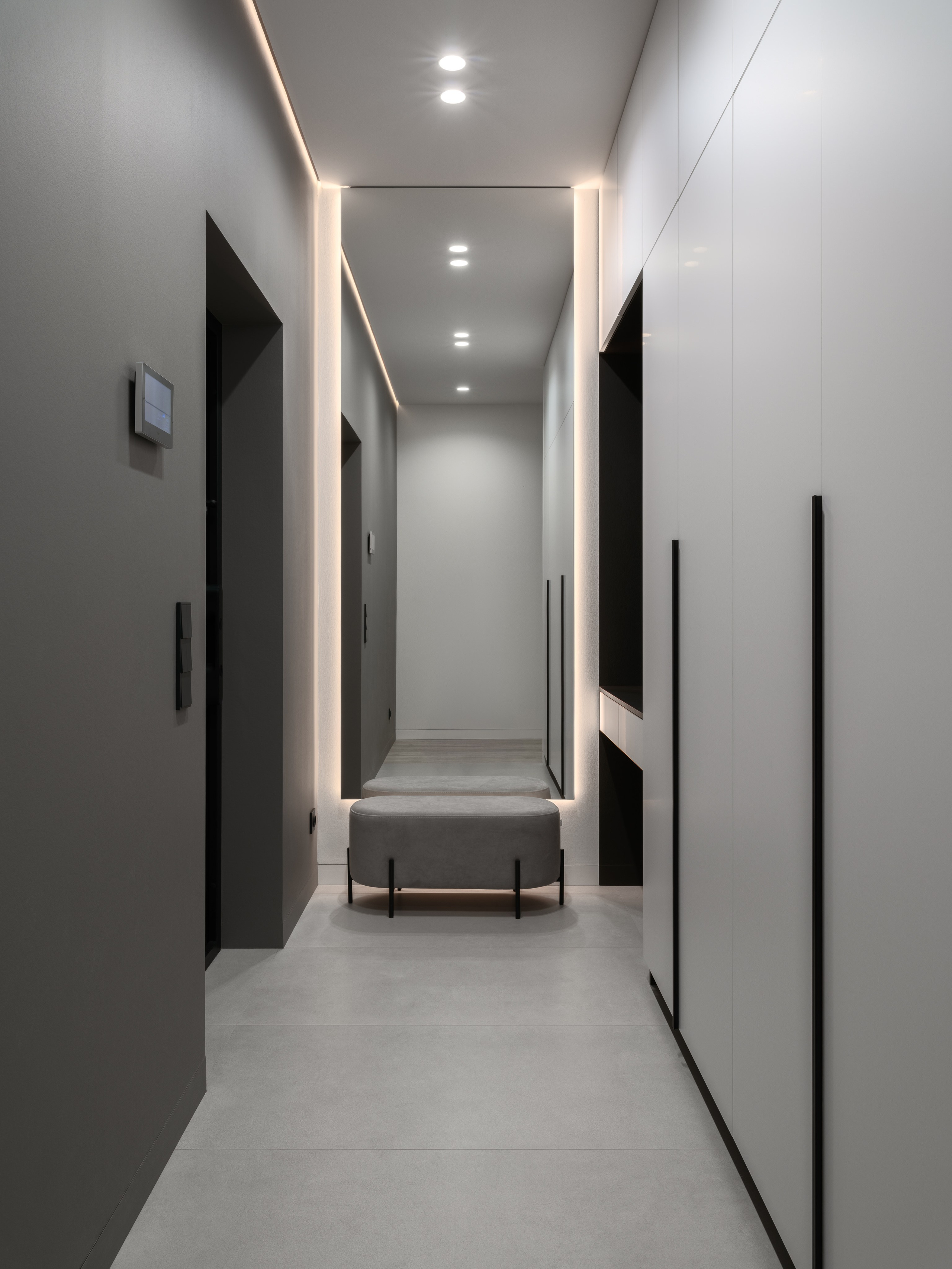 Современный коридор в минималистичном стиле с зеркалом в полный рост, встроенными шкафами и мягкой скамьёй с подсветкой. Автор проекта — дизайнеры Евгения Княжева и Владлена Привалова, фотограф Сергей Денисенко