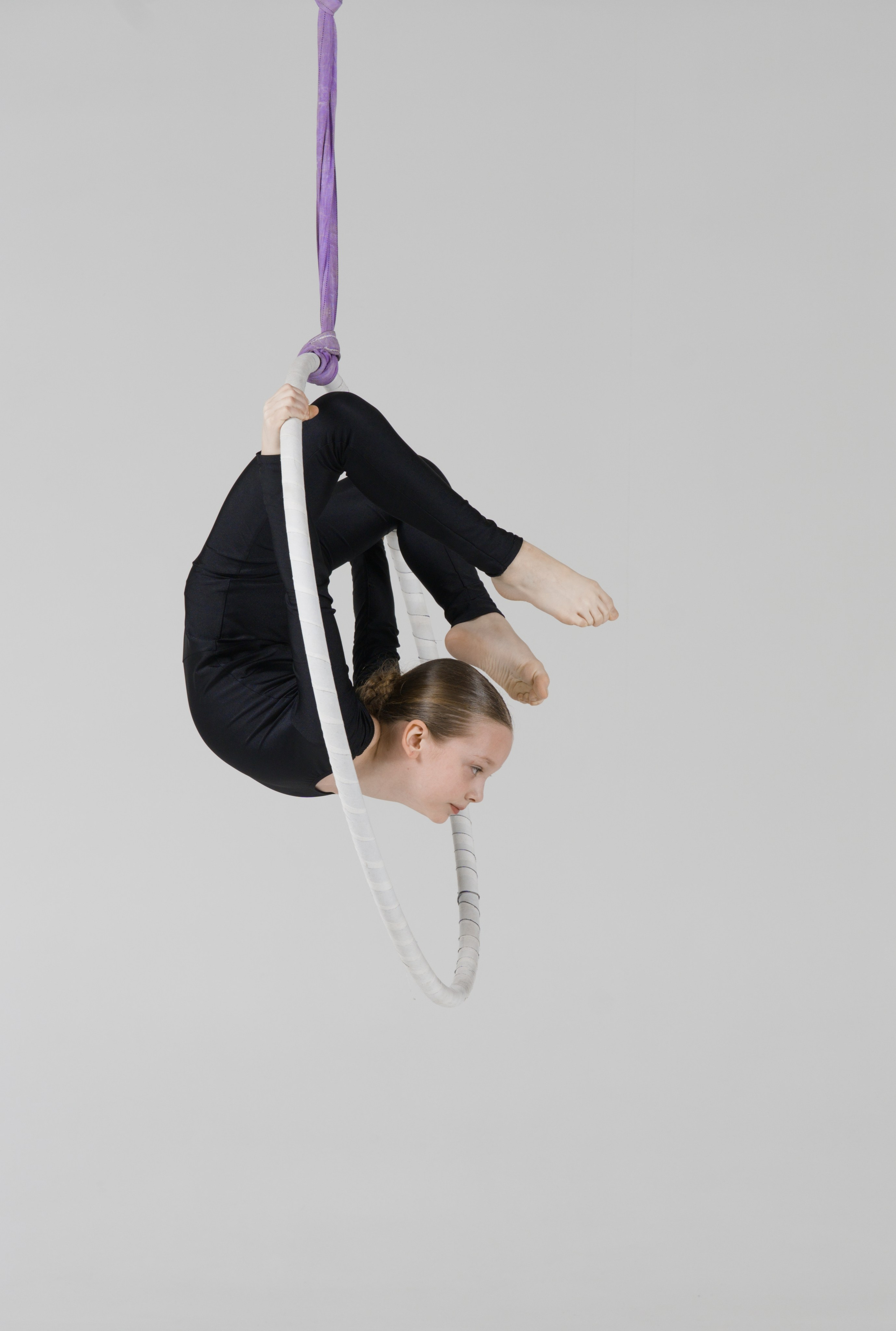 Сложная акробатическая фигура внутри кольца, детальная проработка гибкости в стиле спортивного минимализма