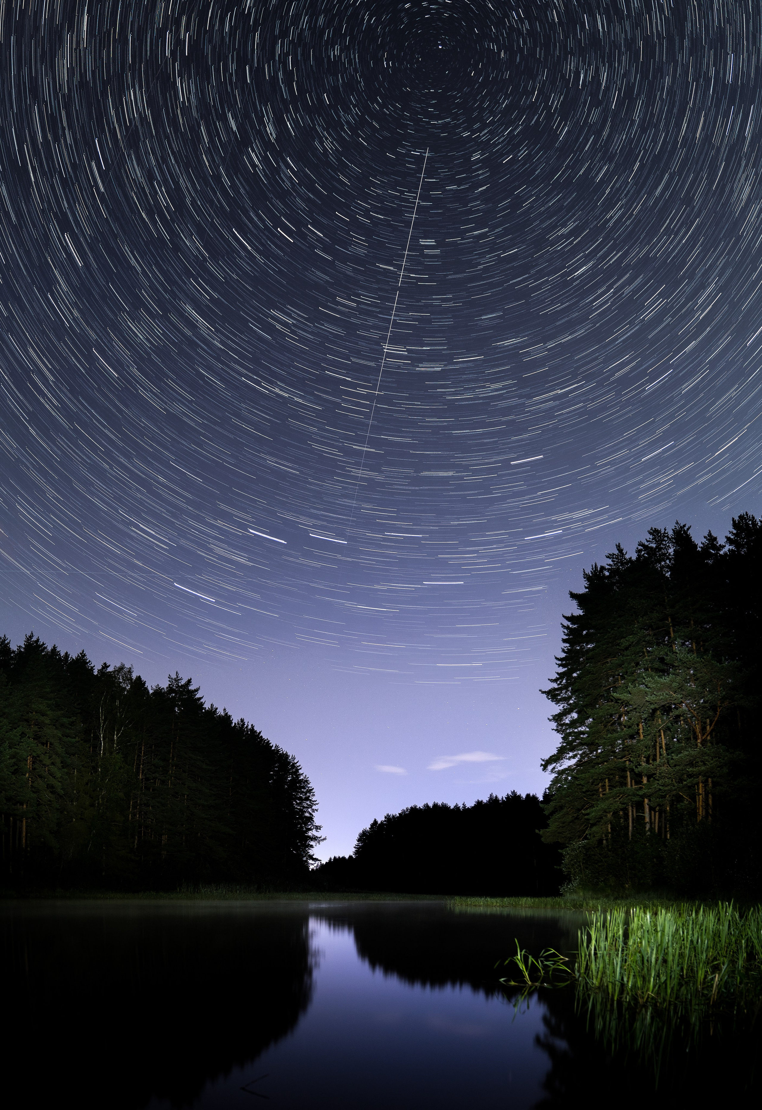 Звёздные следы круговое вращение длинная выдержка ночное небо над спокойным озером тёмный лес синие сумерки атмосферный пейзаж фото Евгений Мальцев Санкт-Петербург.