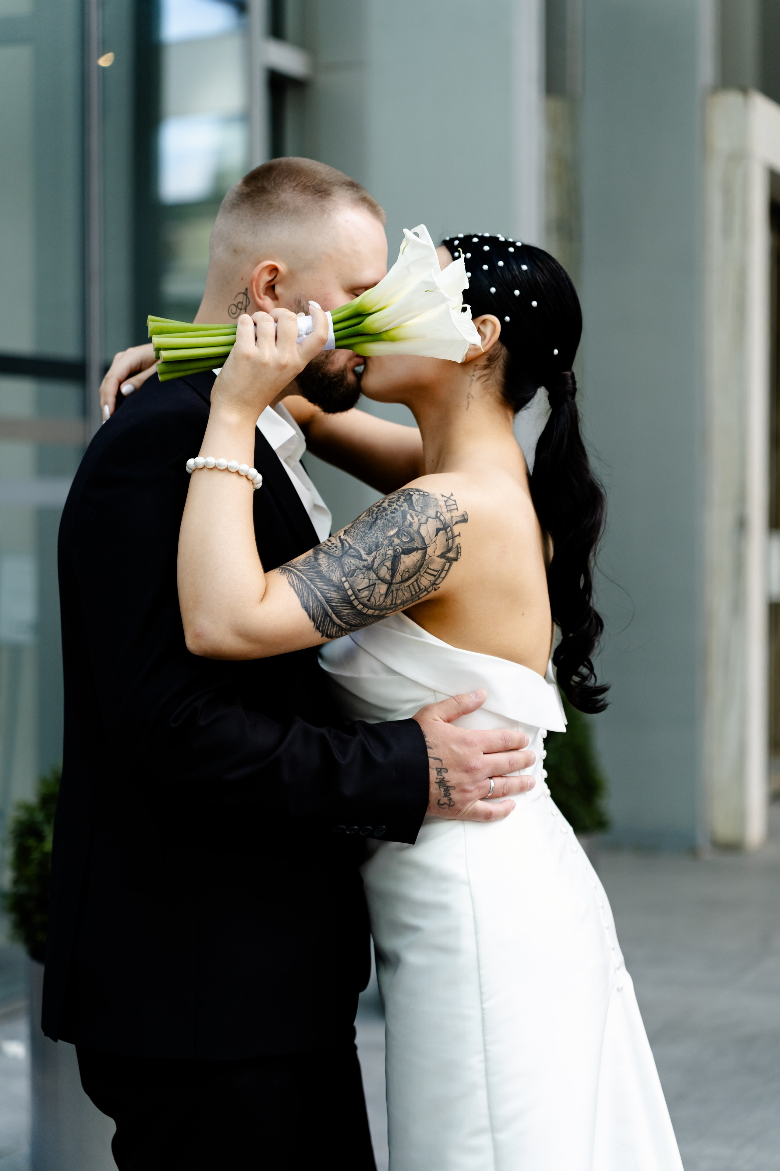 Невеста закрывает букетом лицо жениха Свадебная фотосессия