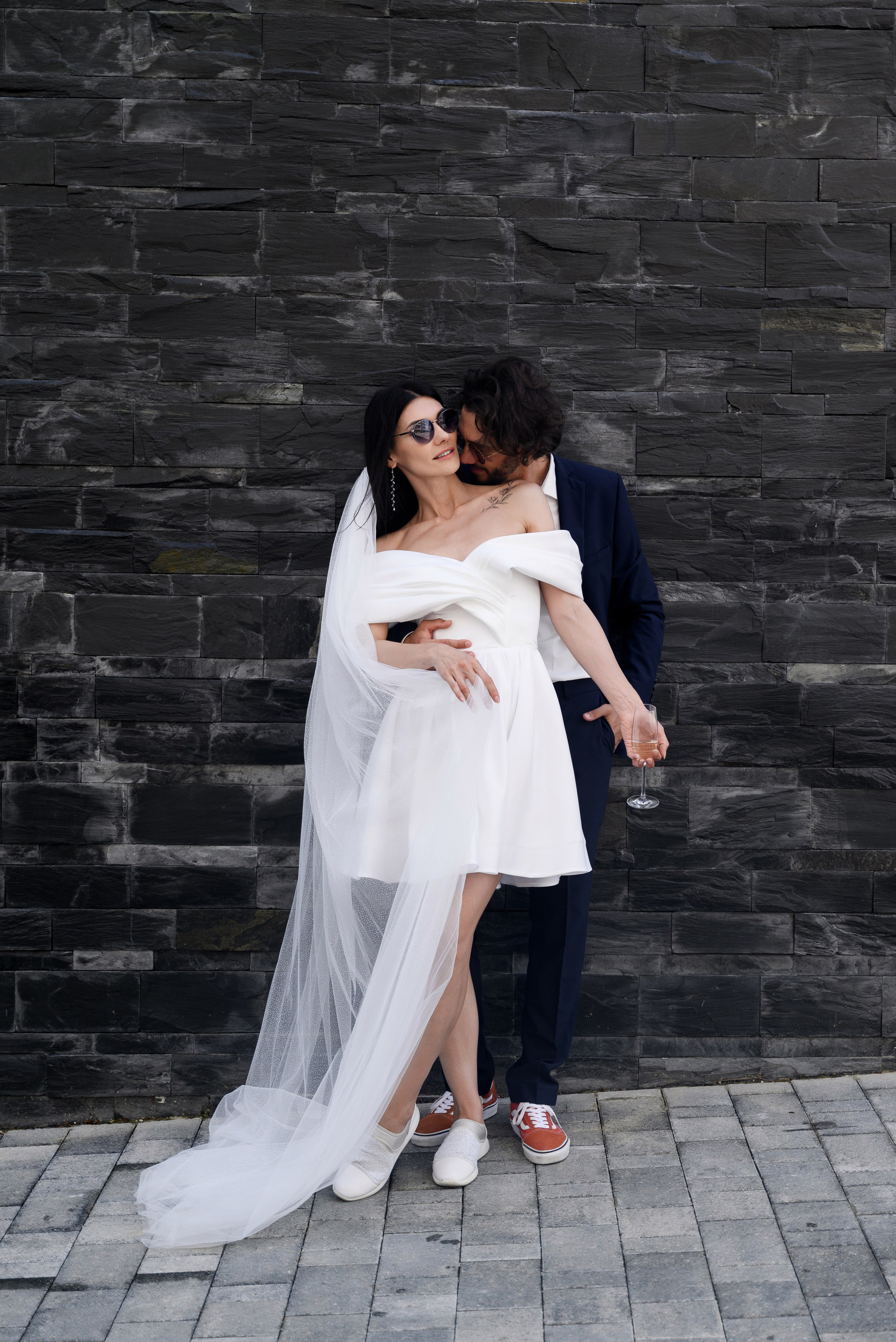 Идеальные свадебные моменты, молодые покатились на стену жених целуют невесту шею 