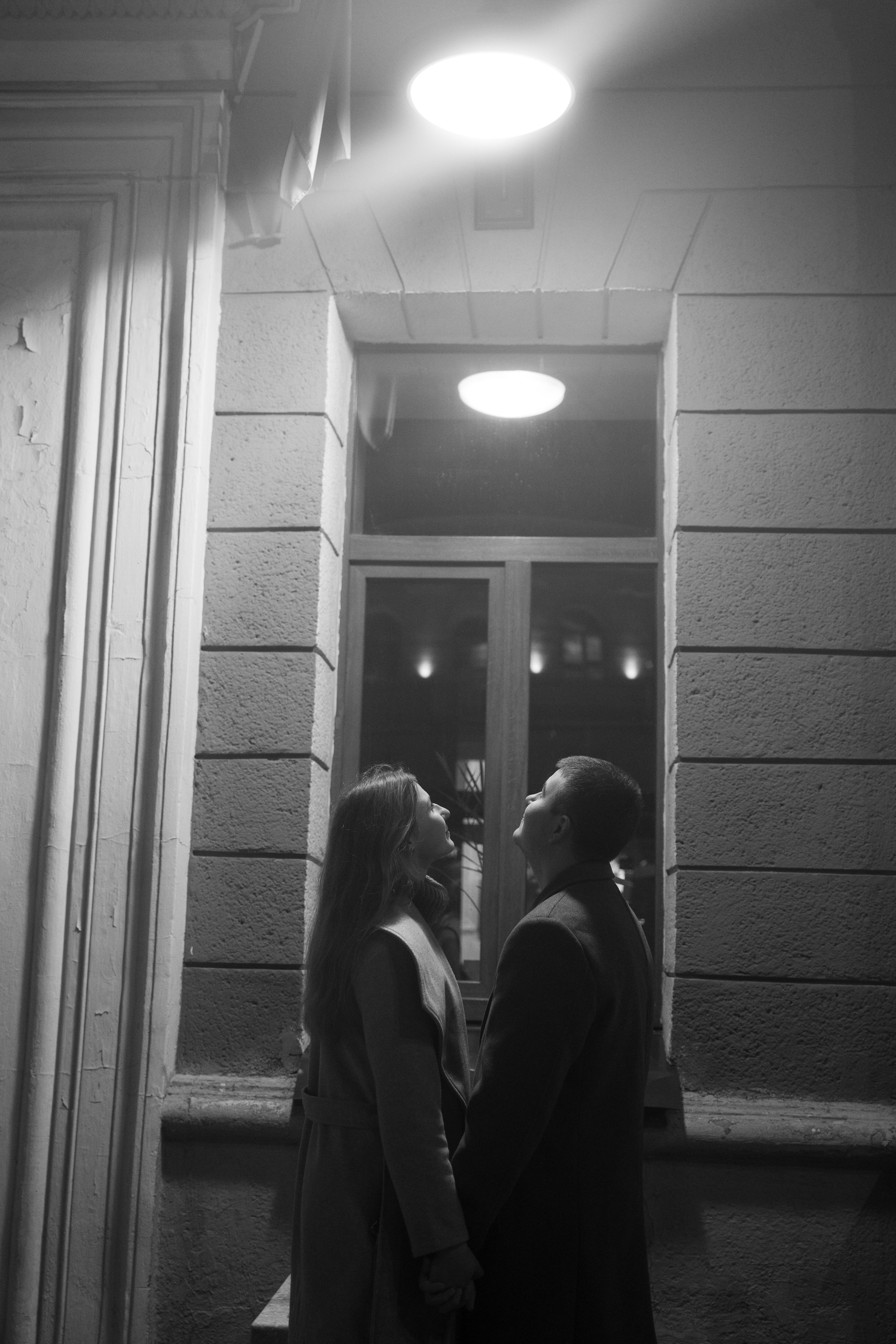 парень с девушкой стоят под лампой на улице у окна