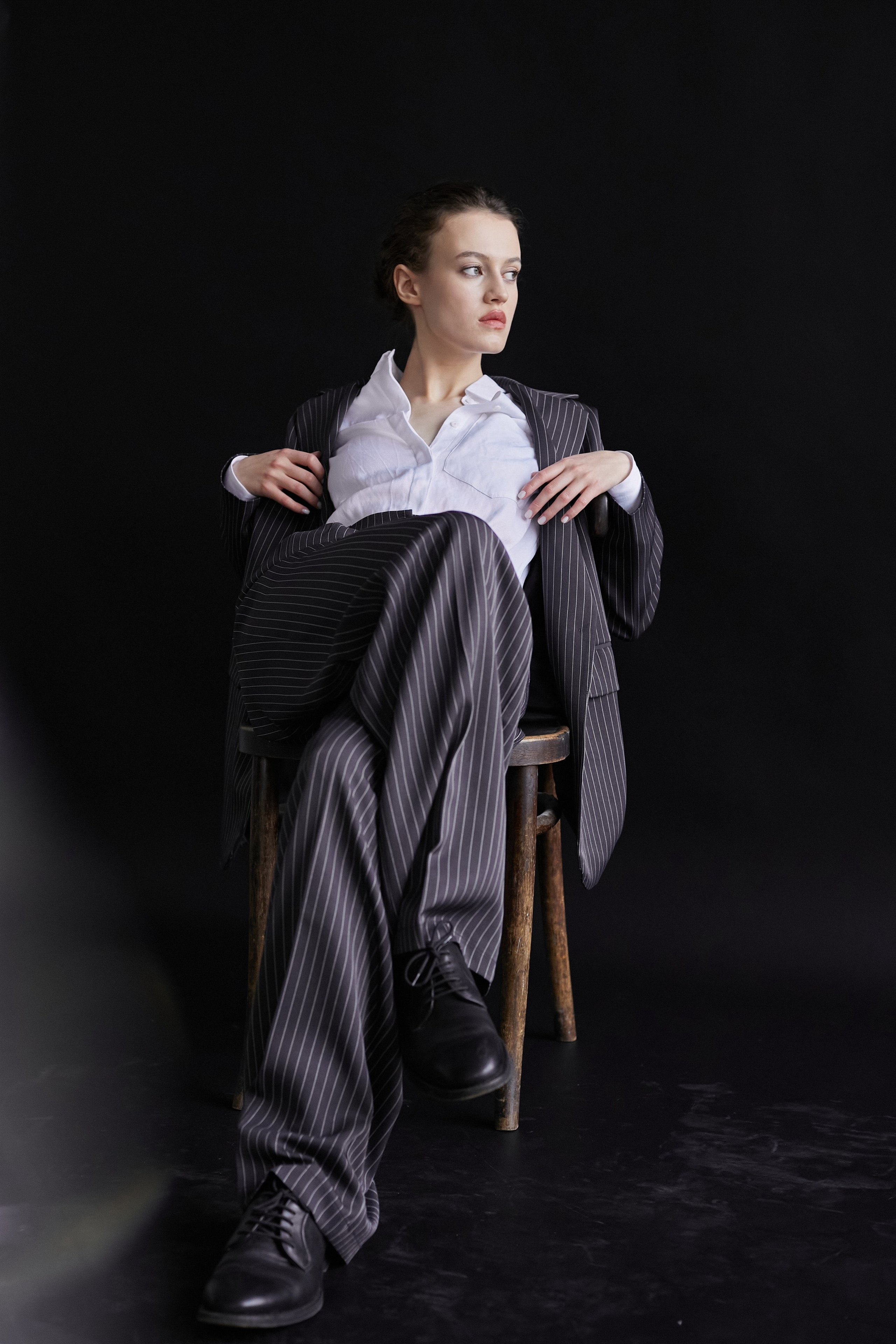 Фотограф в Москве. Студия. Студийный портрет. Девушка в пиджаке. Девушка на стуле на черном фоне. Красивая девушка в мужском костюме. Женский портрет.