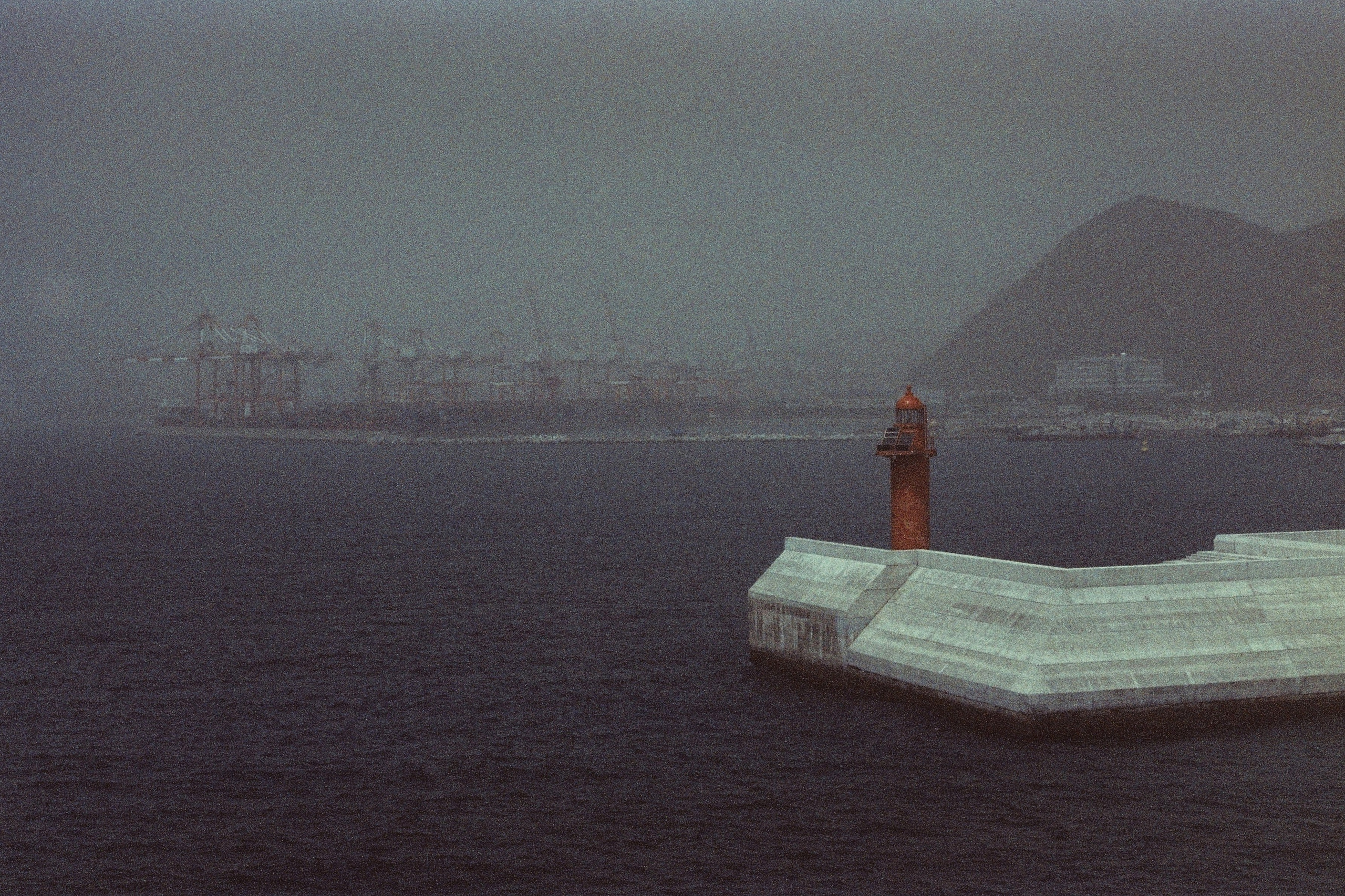 морской пейзаж. волнолом. маяк. туманные воды.
