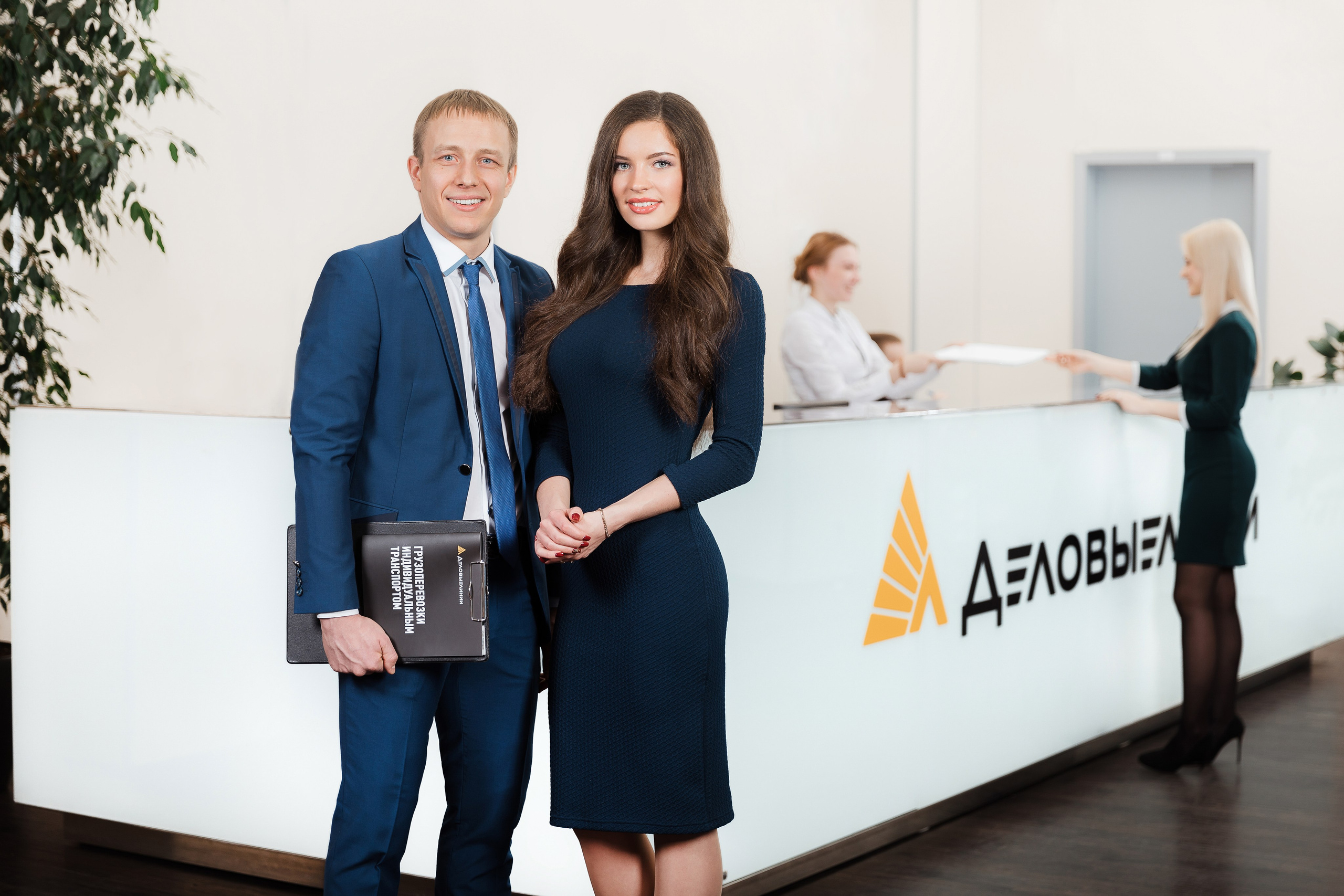 Деловой портрет сотрудников компании возле стойки ресепшена