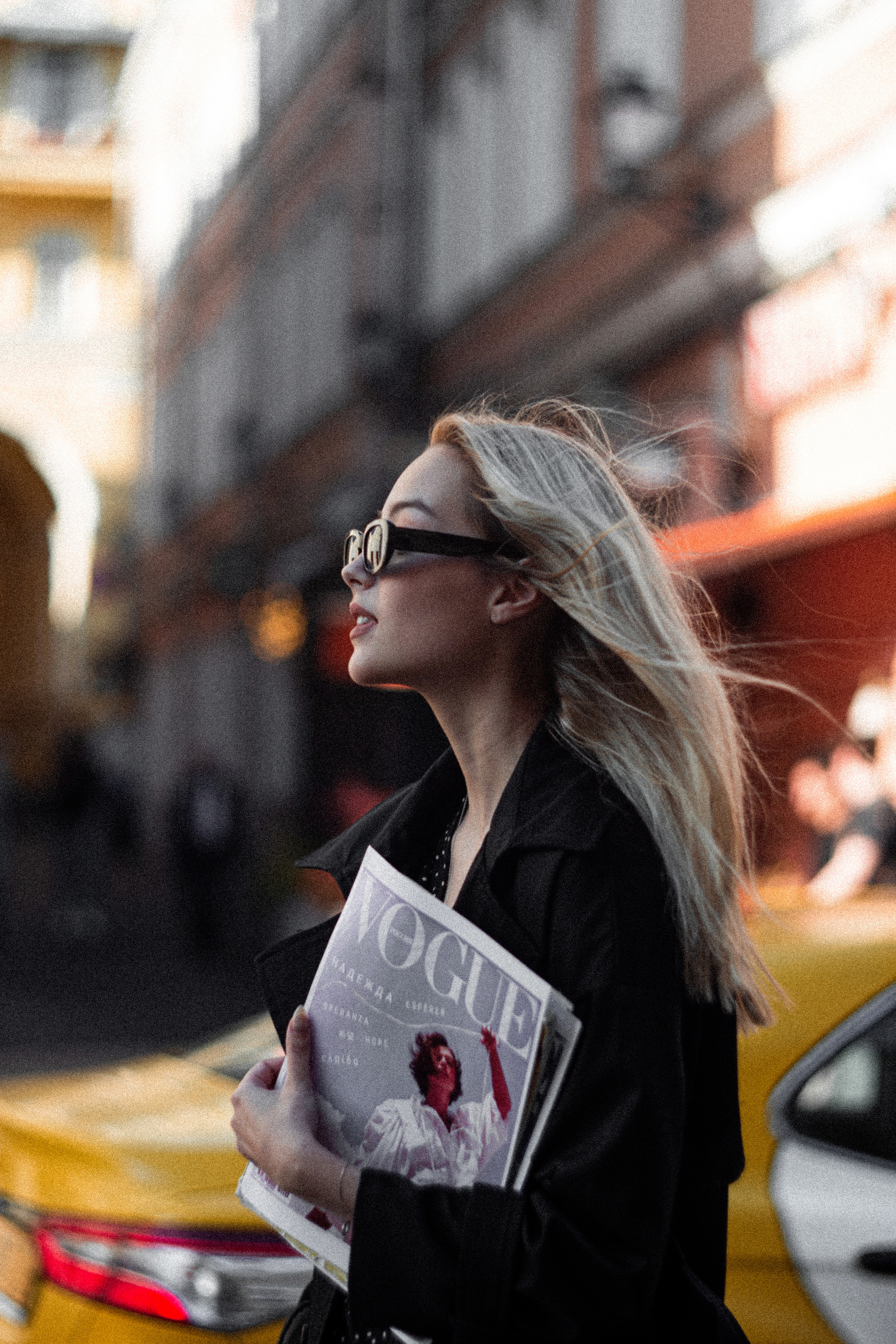девушка ловит такси в большом городе и ее снимают на фотосессии
