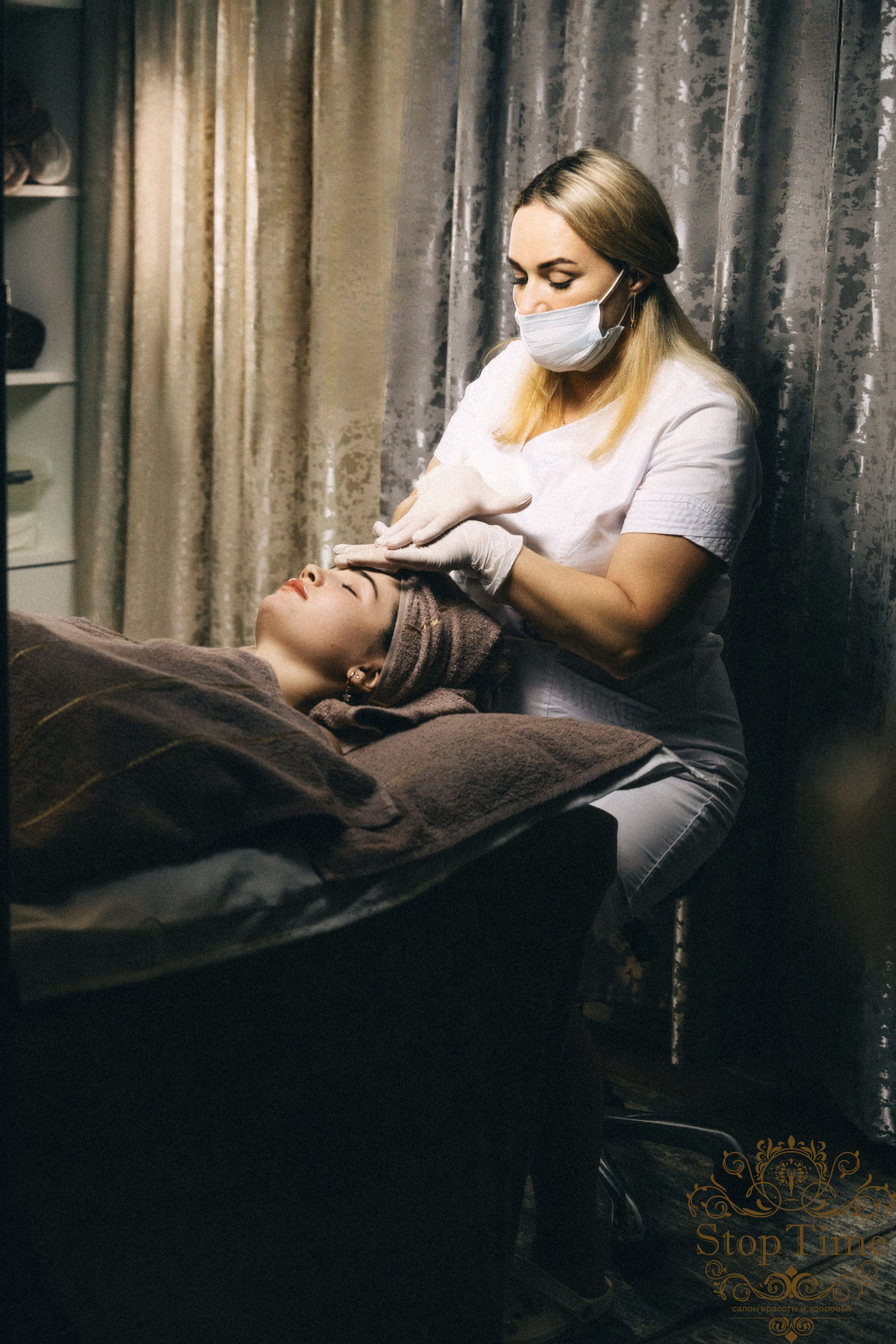 массажист делает массаж лица девушке