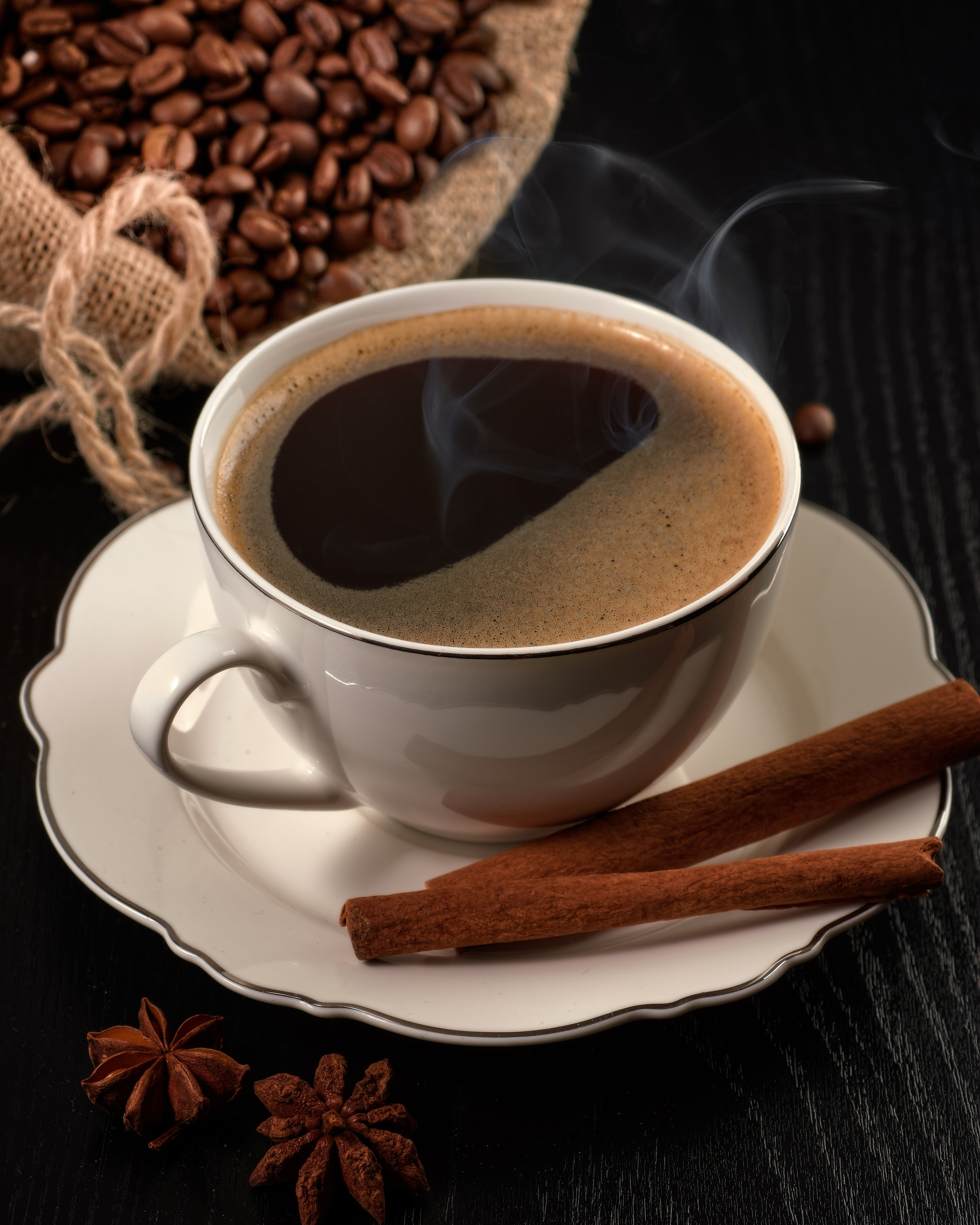 кофейная чашка с паром и мешком зерен кофе