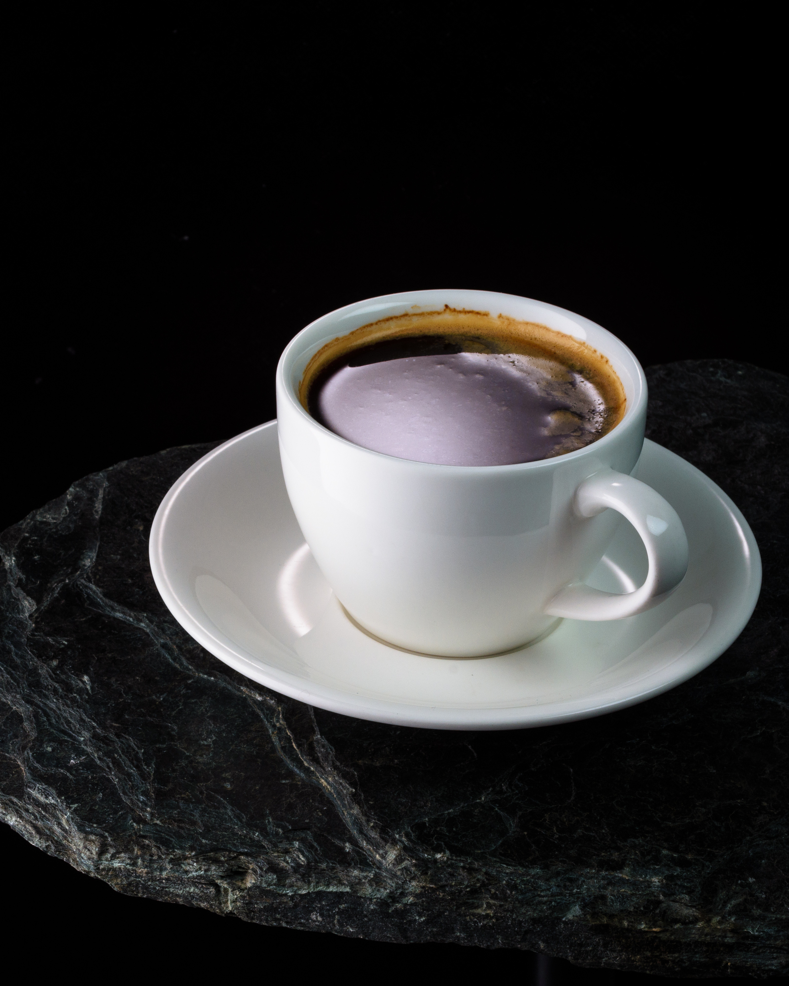 кофейная чашка с бликом на камне