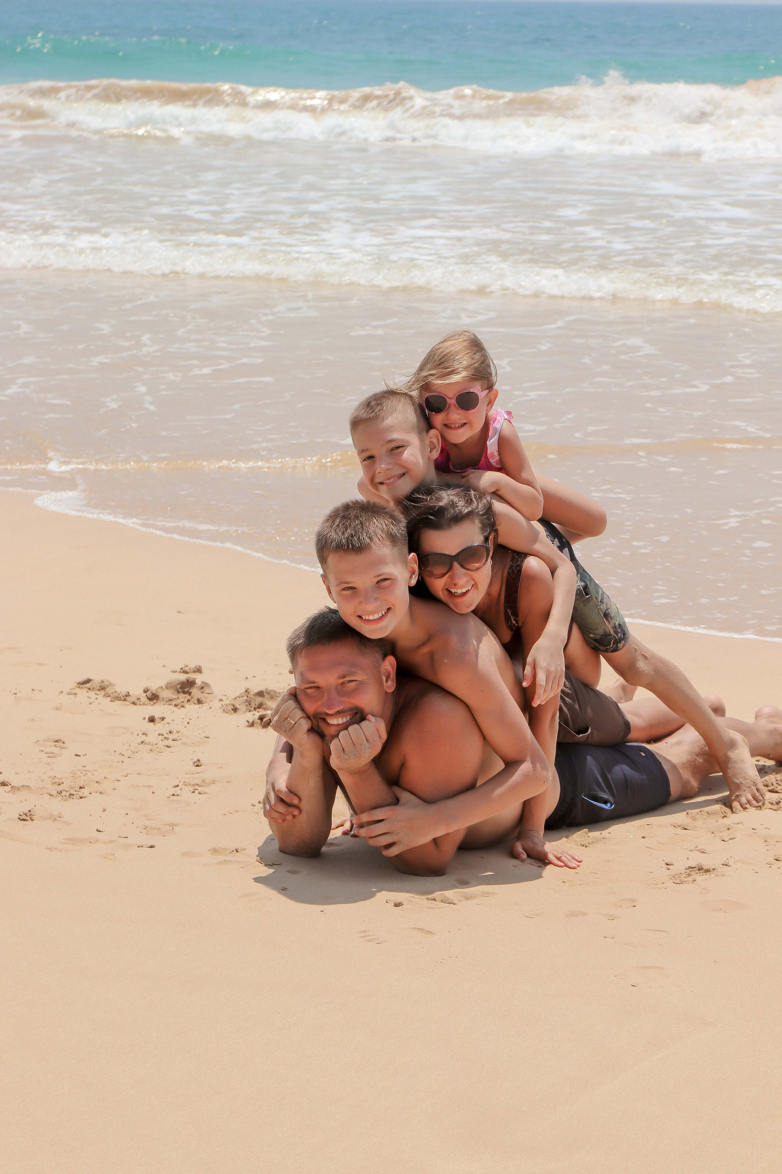 «Семейные объятия у воды: тёплые моменты на фоне бирюзовых волн»