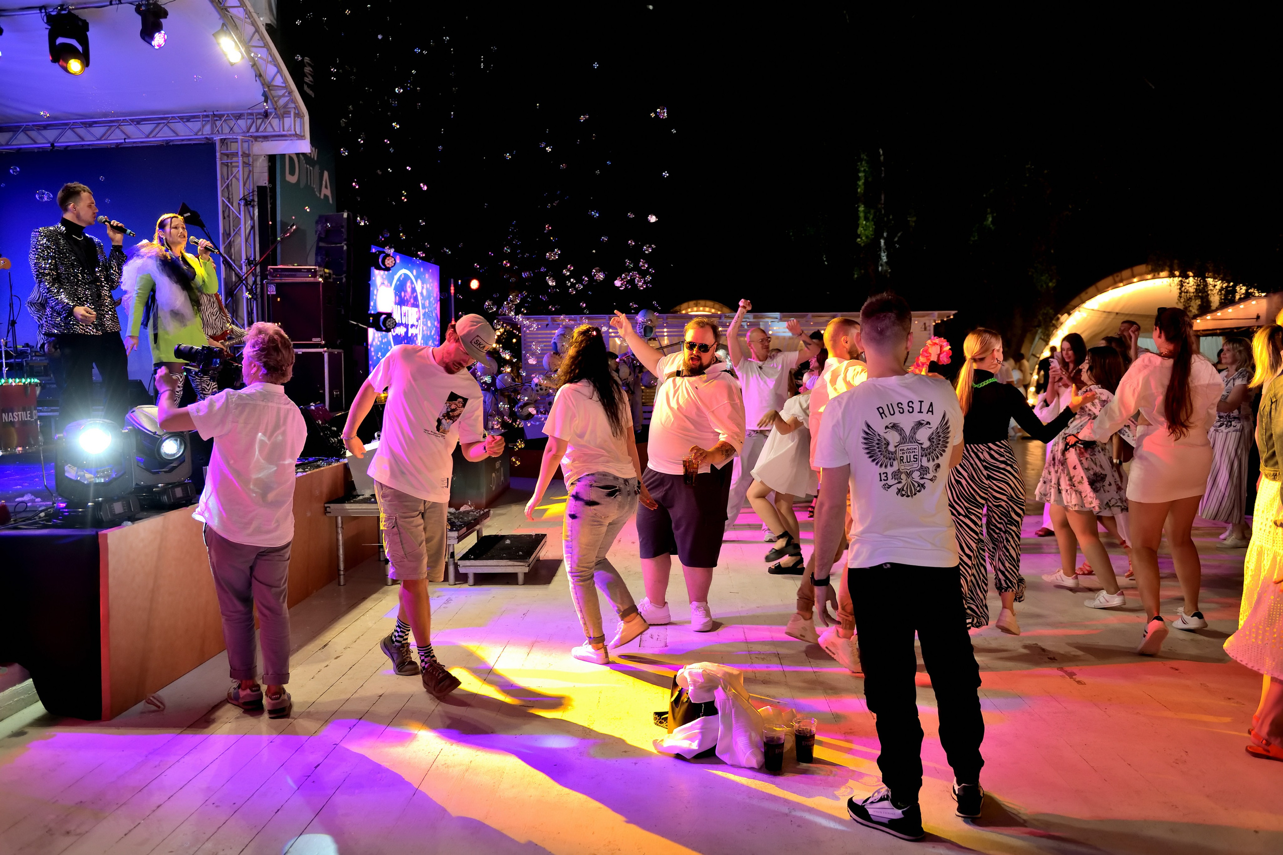 "Веселая аудитория на летнем празднике в парке "Березы".