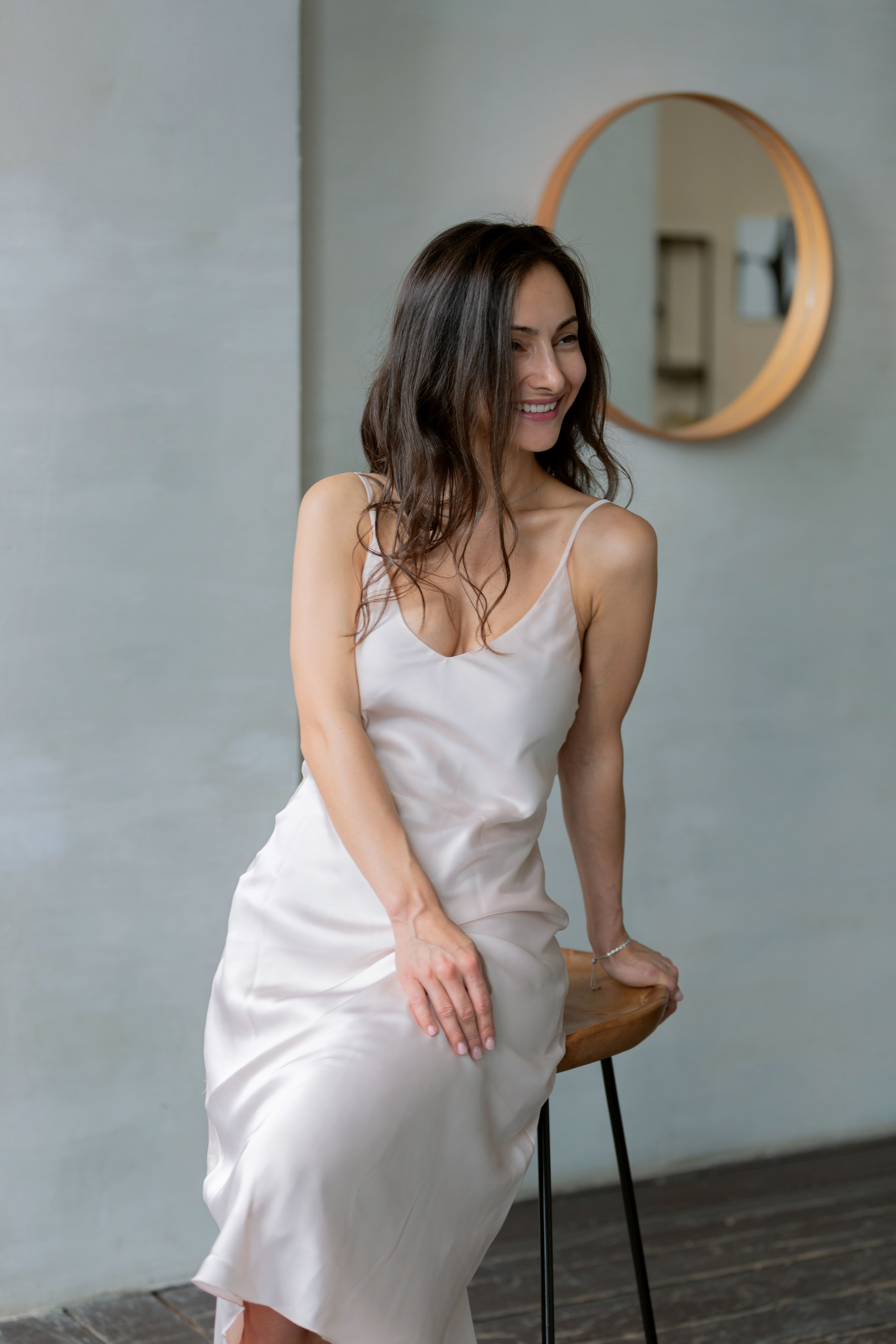 Девушка у стены в белом платье — чувственный портрет в естественном освещении.