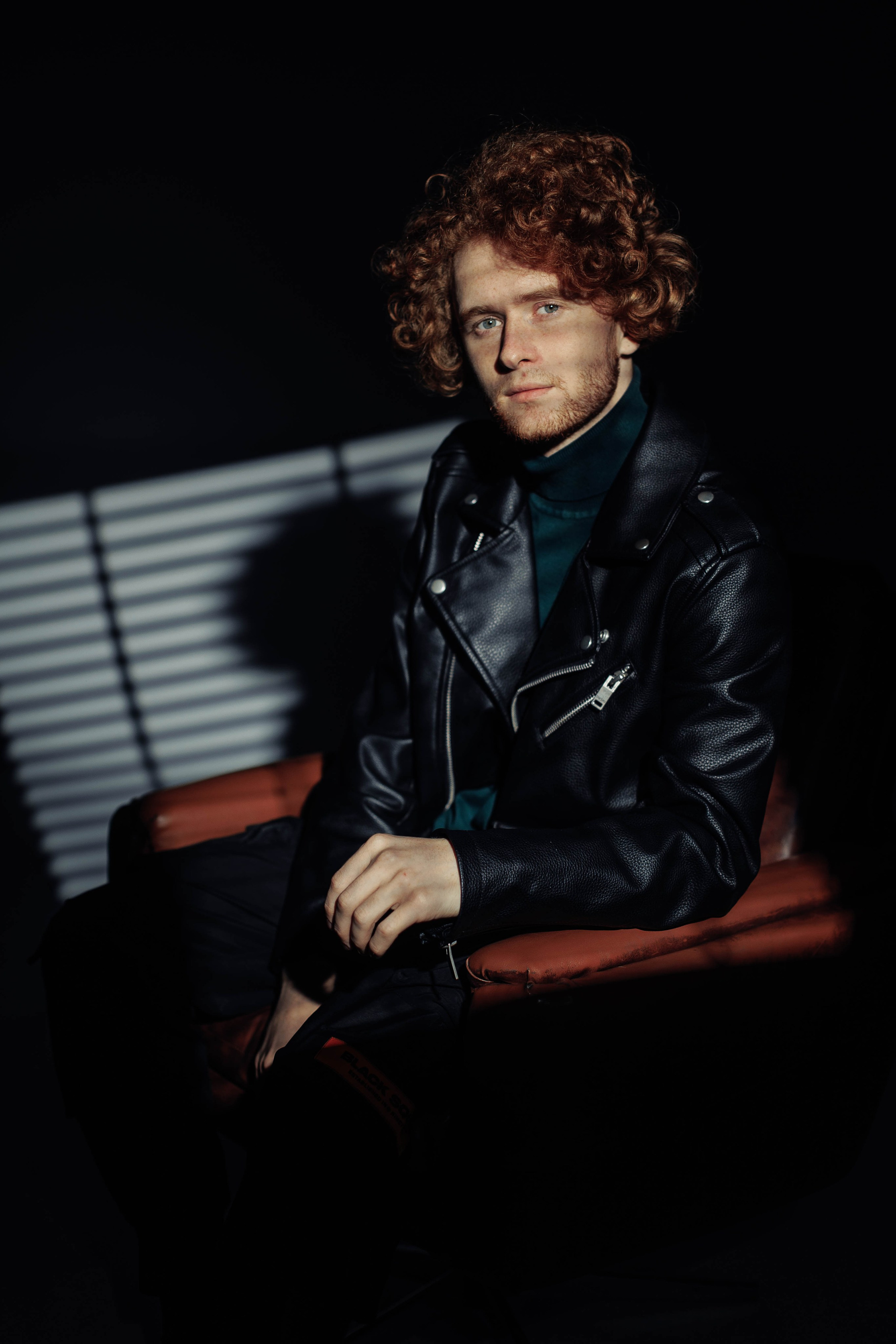 Мужчина сидит в кресле, портрет с фактурным светотеневым рисунком.