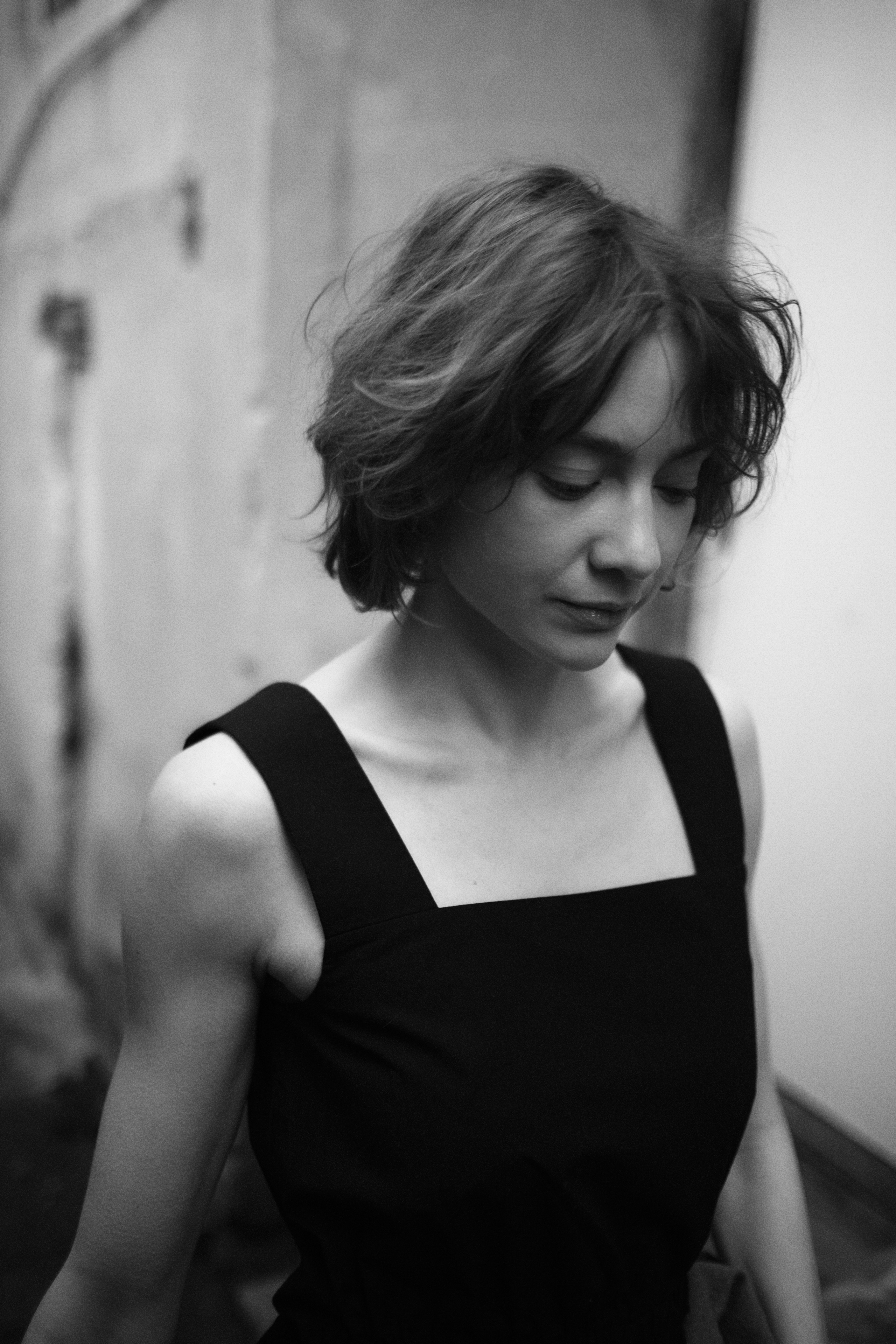 Черно-белый кадр: задумчивая женщина в переулке