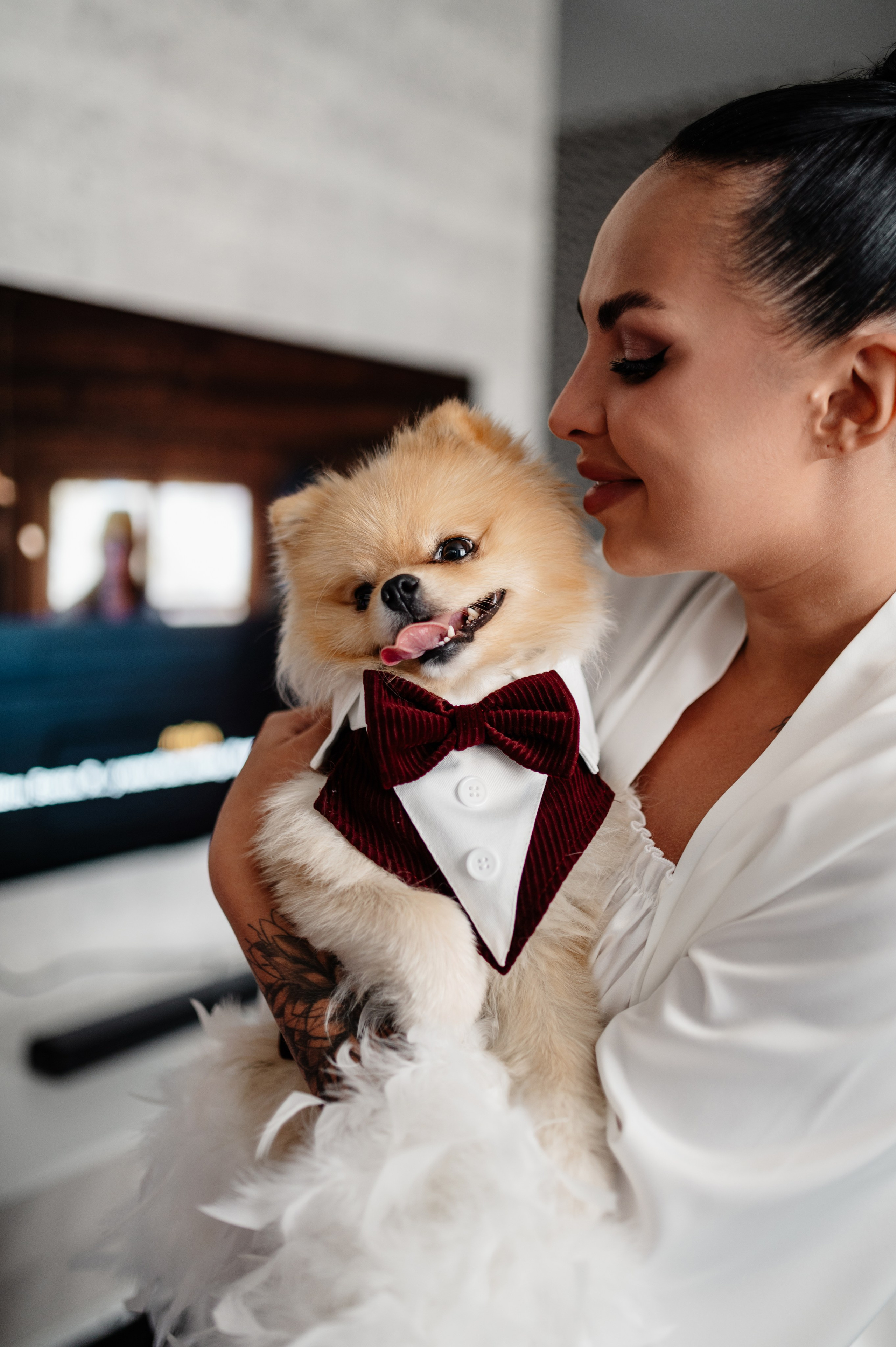 Невеста держит на руках свою собаку в таком же костюме как у жениха.