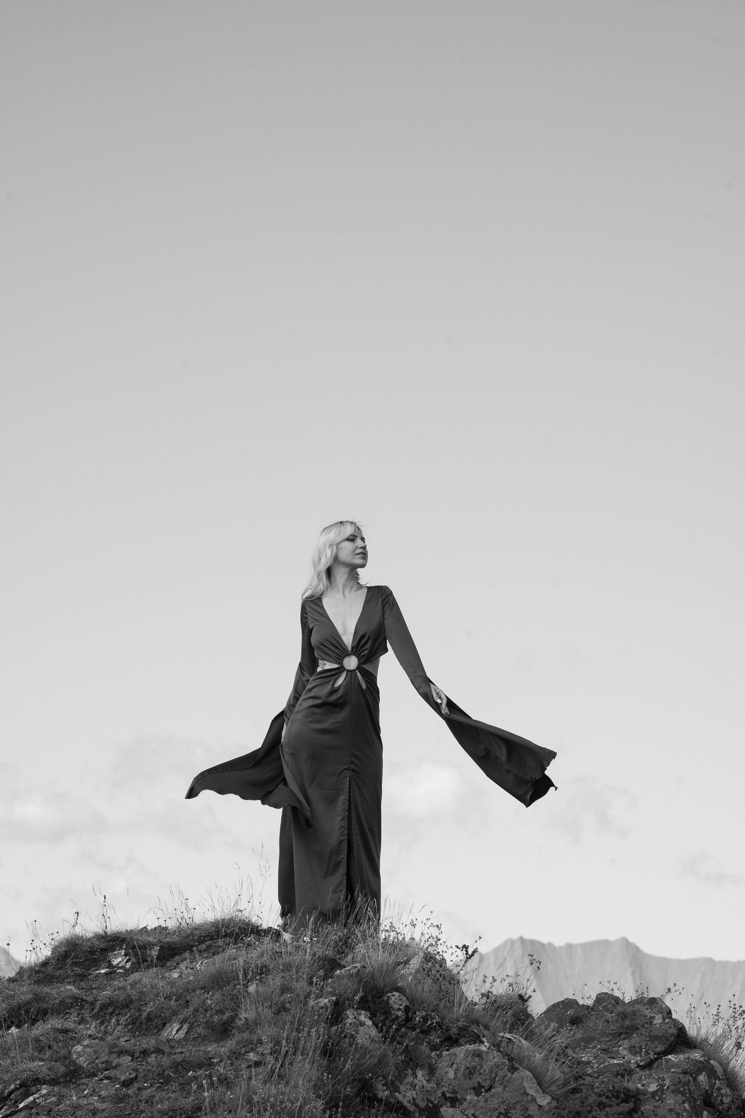 Снимок девушки стоящей на верху горы