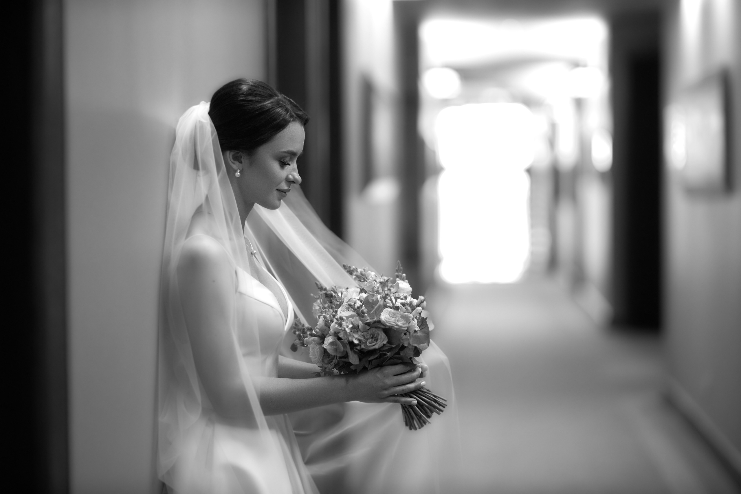 глубокий портрет невесты в профиль в отеле смотрящей на букет