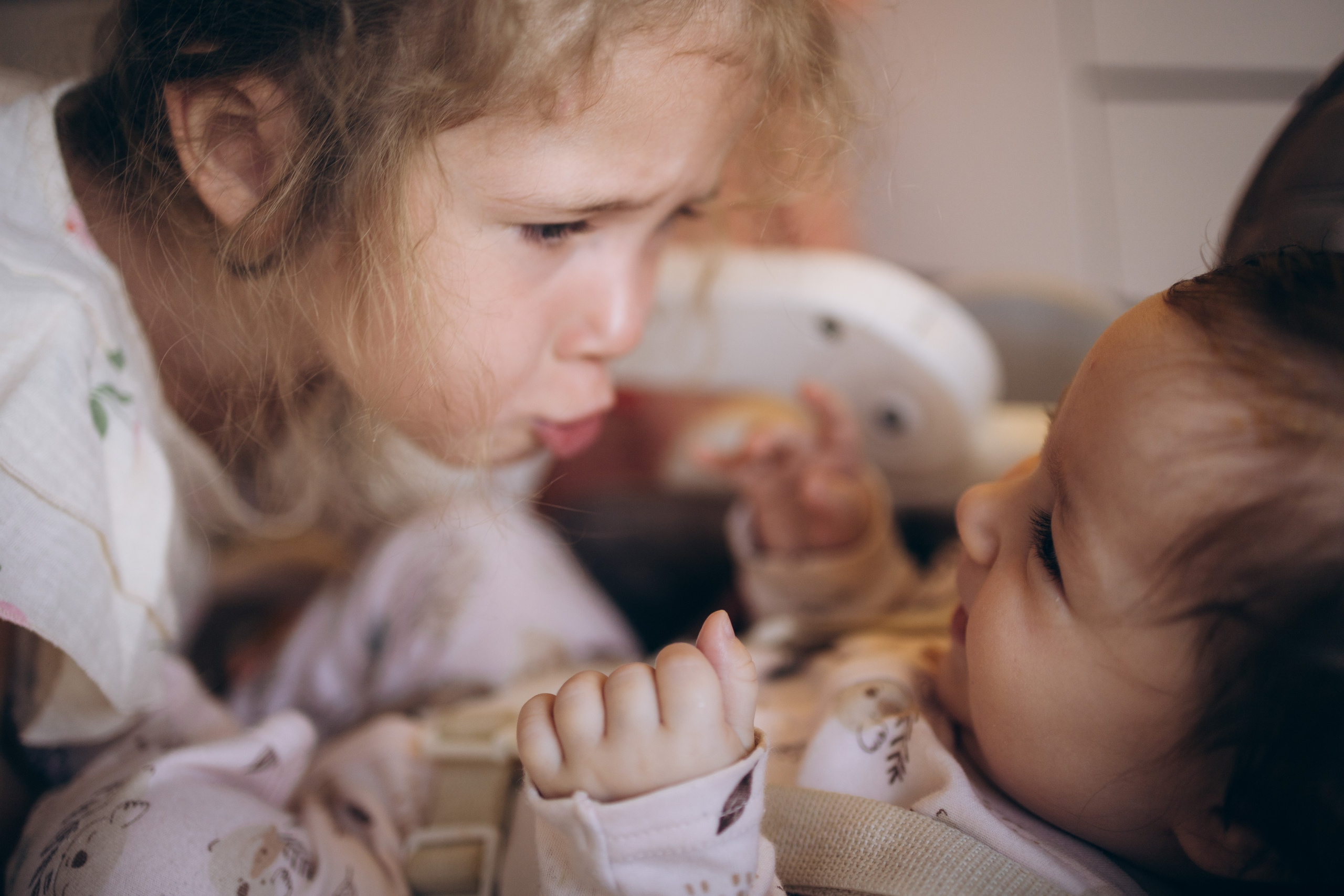 старшая дочка играет с младшей сестренкой