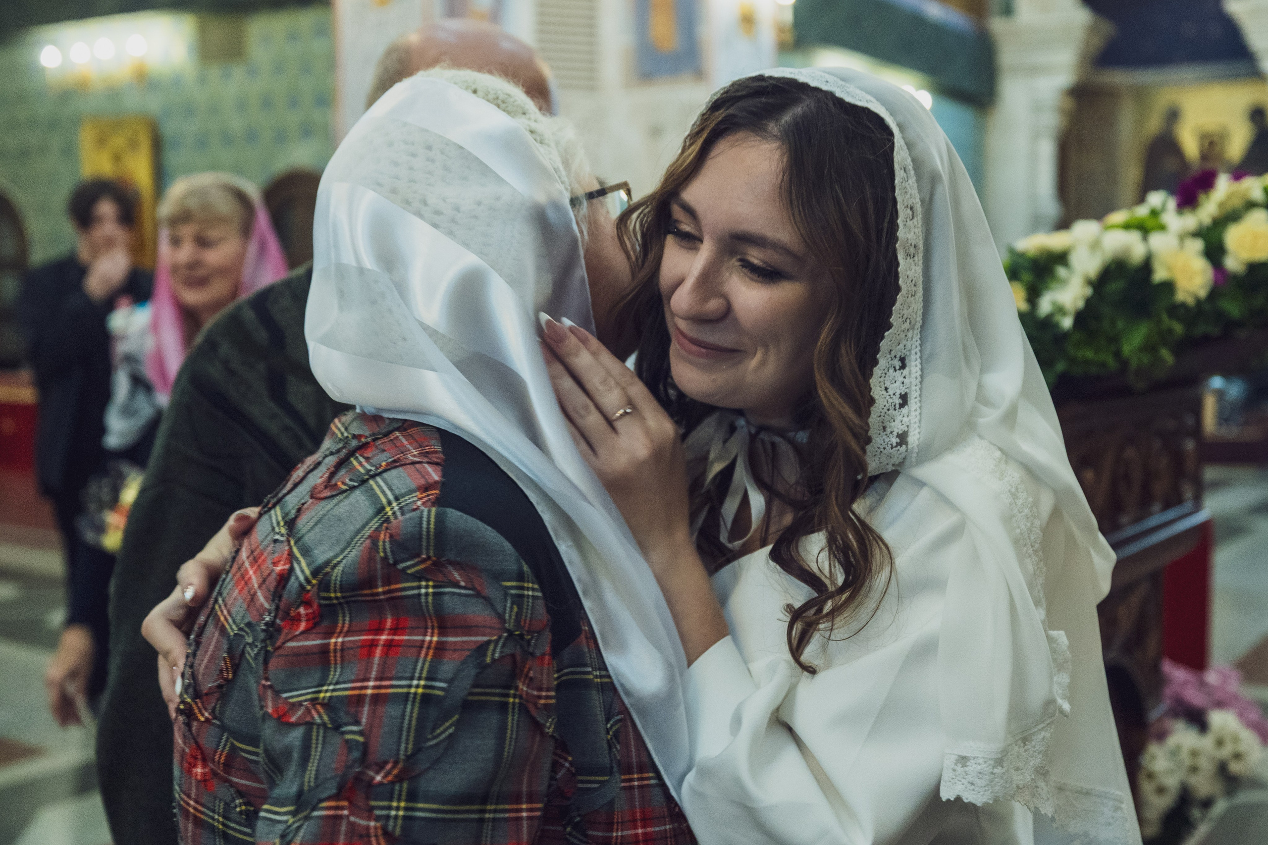 Невеста обнимает пожилую женщину после венчания, живой момент, тёплый свет — Екатеринбург, Илья Антропов​​​​​​​​​​​​​​​​