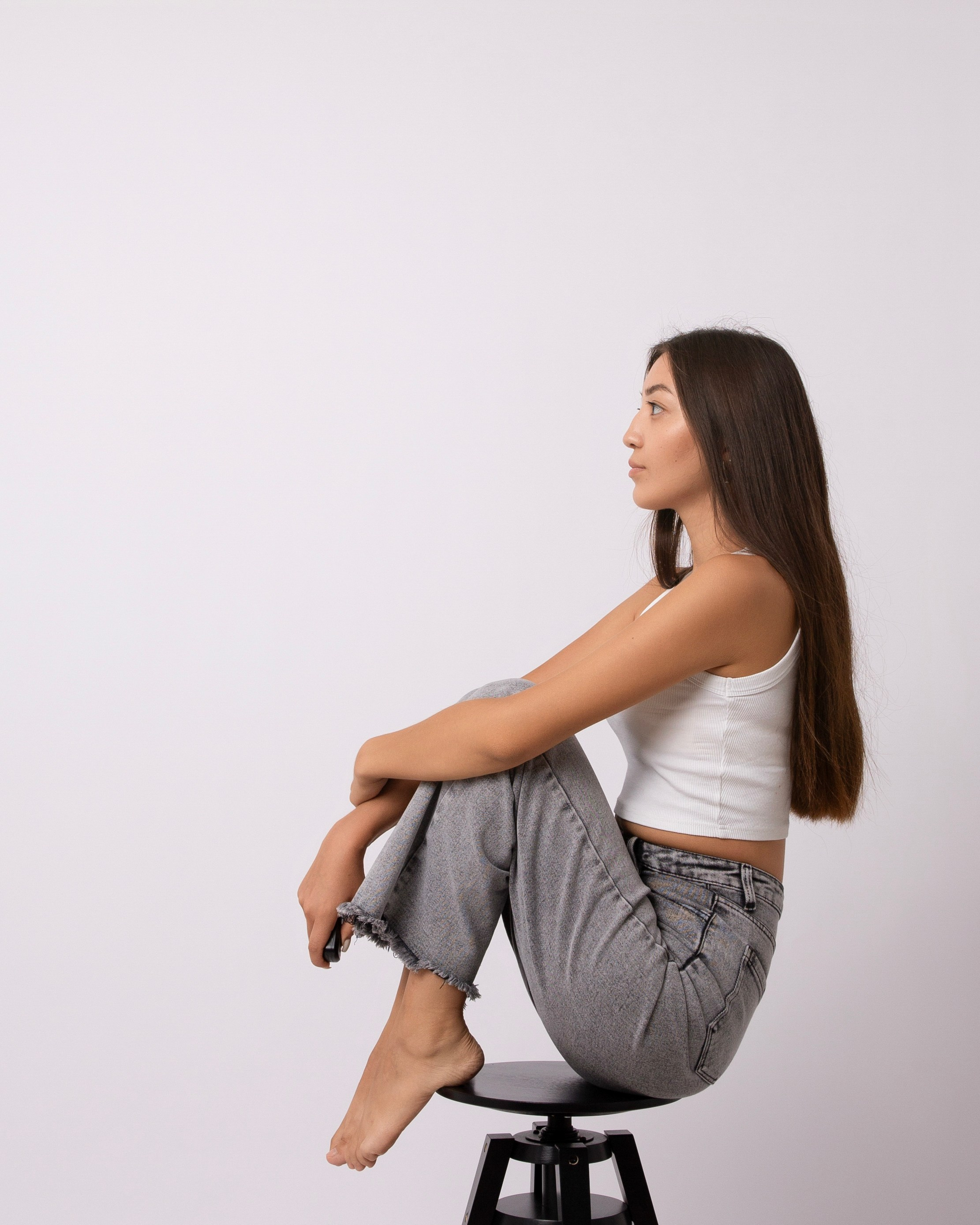 Автопортретная фотография девушки сидит на стуле в профиль