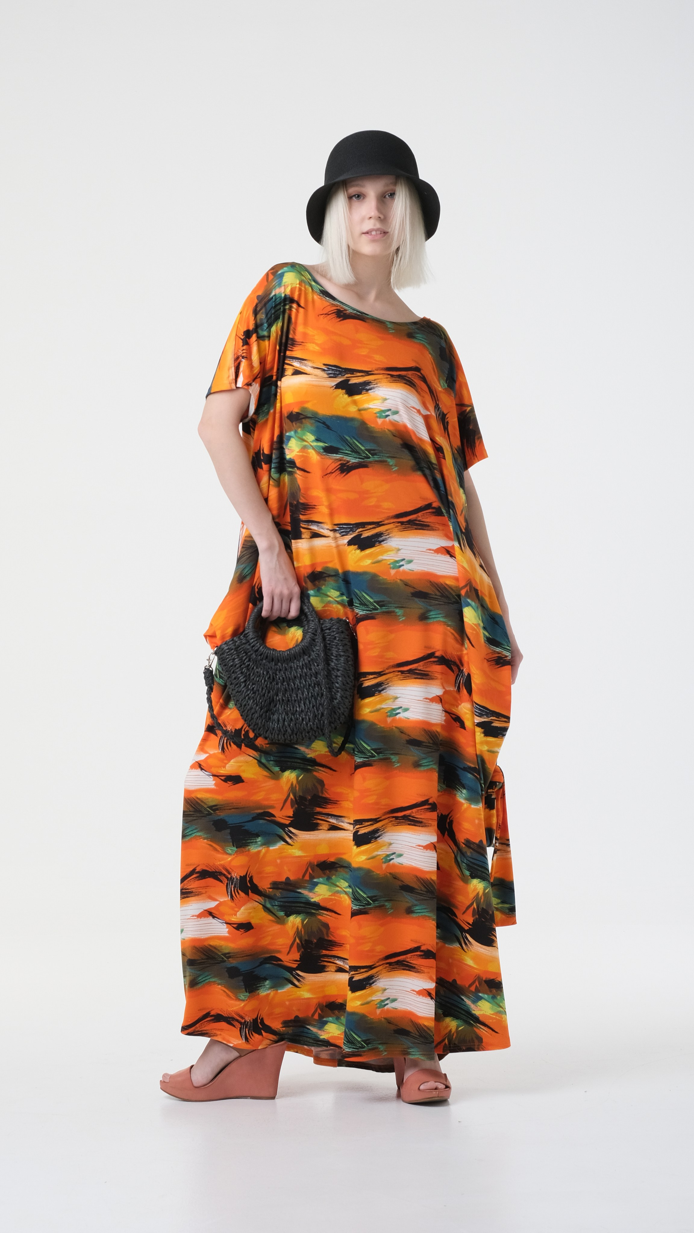 Яркая качественная съёмка для каталогов в Москве. Фотосъёмка на циклораме. Яркое платье с оранжевыми оттенками, шляпка, черная сумка.