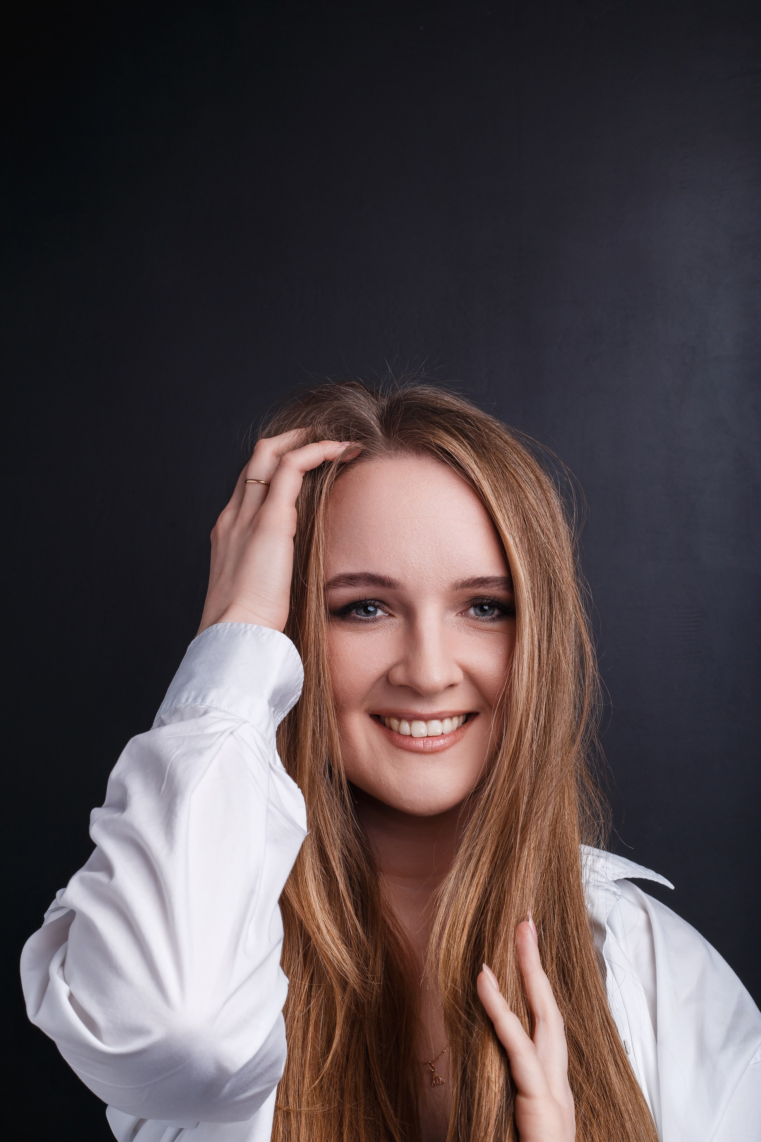 портрет девушки в белой рубашке на черном фоне