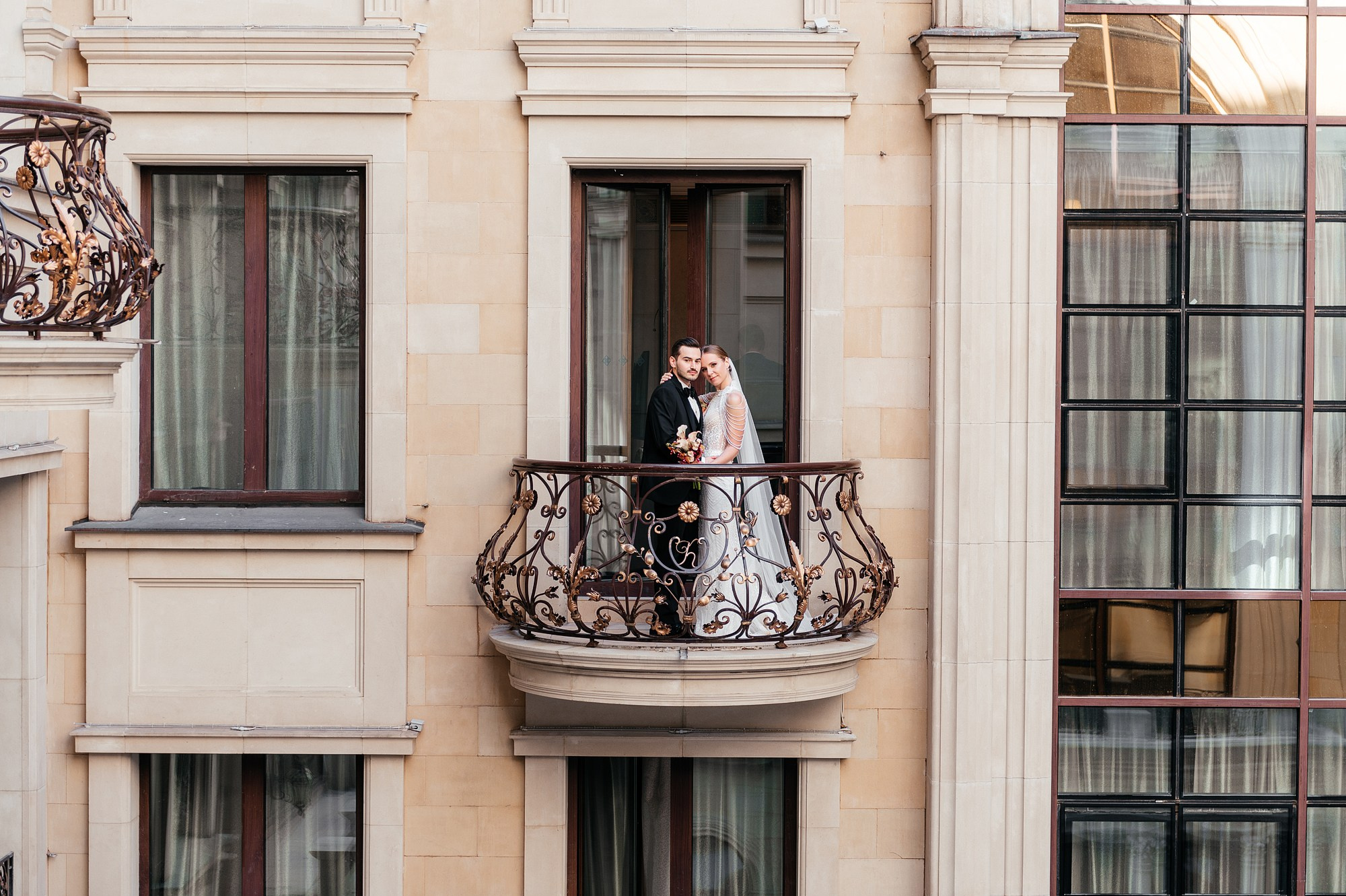 Молодожены стоят на балконе отеля в центре москвы.