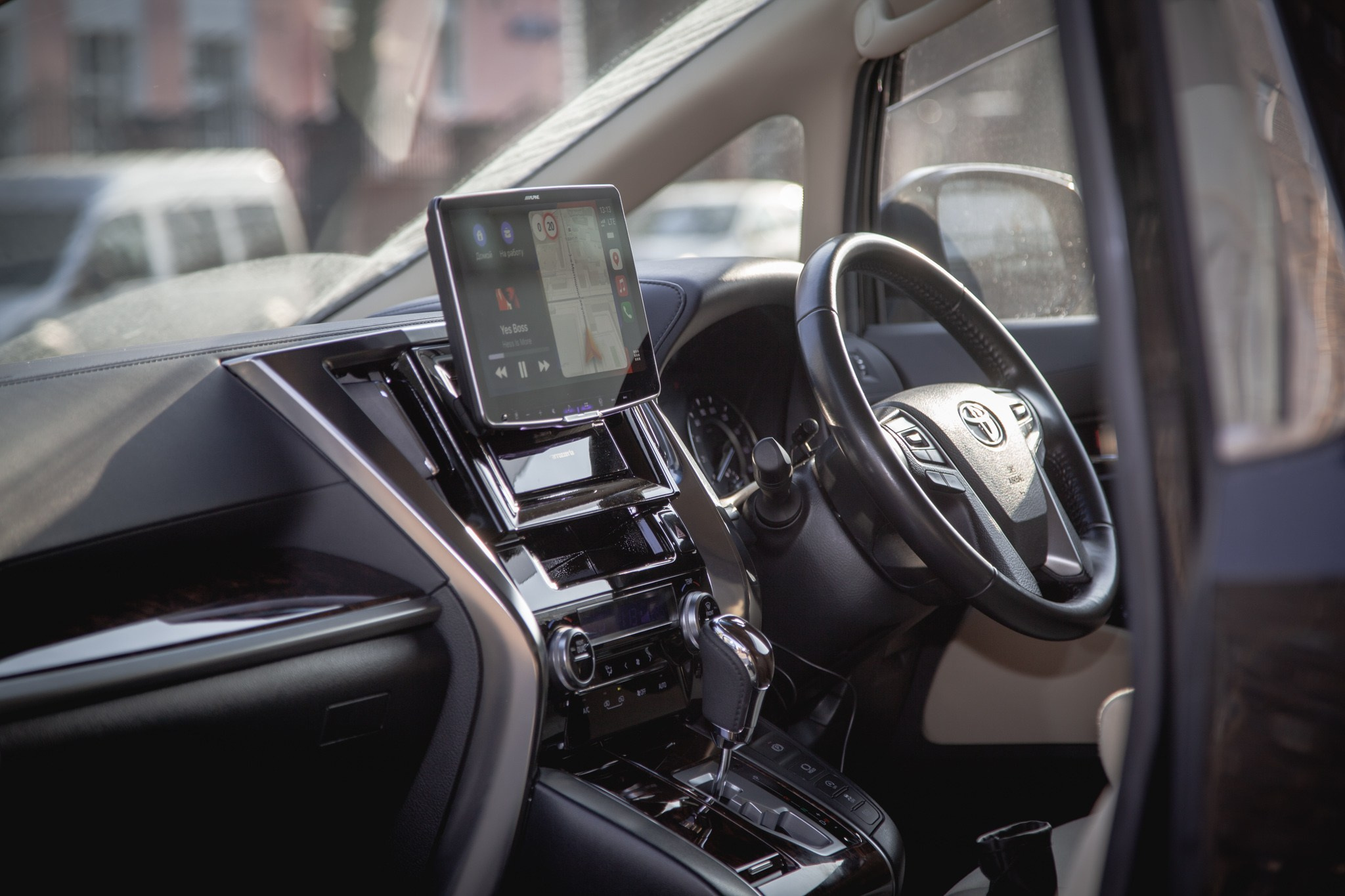 Интерьер современного авто с мультимедийной системой, рулевым колесом и автоматической коробкой передач. Черно-белый дизайн подчеркивает премиальность.