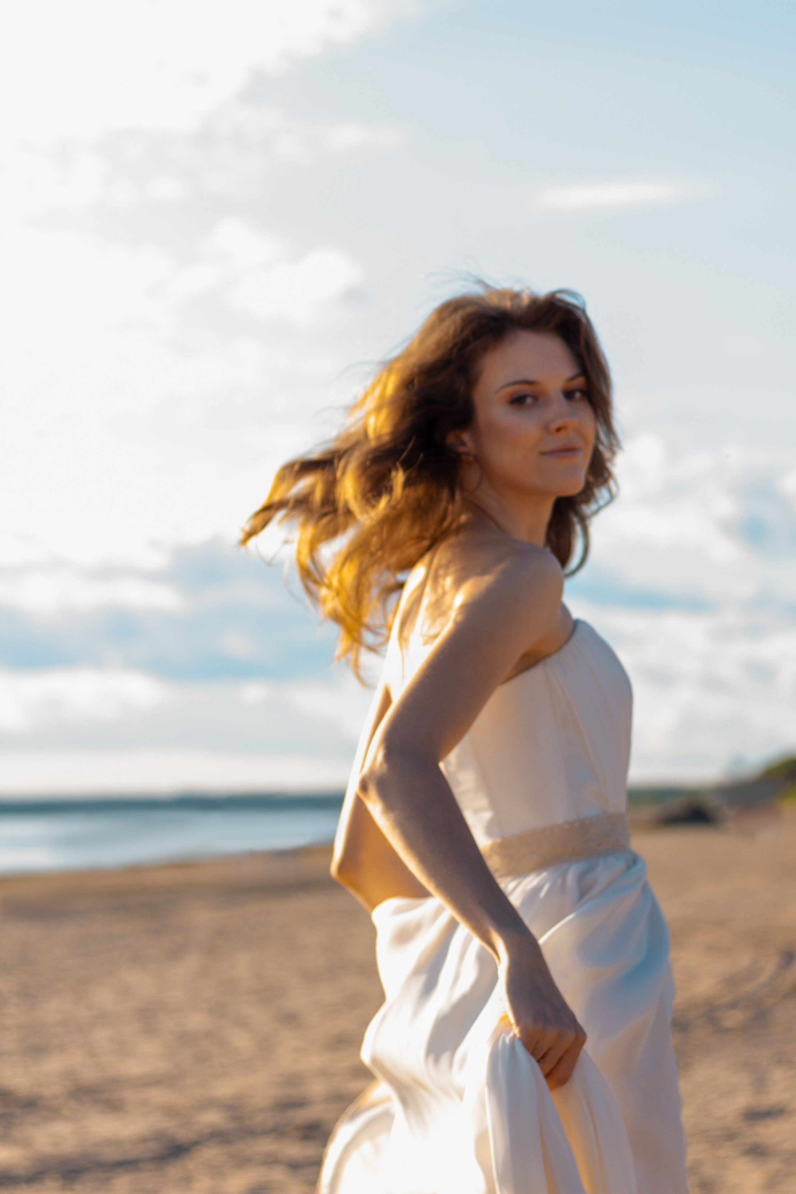 Девушка на берегу залива в белом платье. Девушка с развивающимися волосами на ветру. Фотограф СПб и Лен.области.