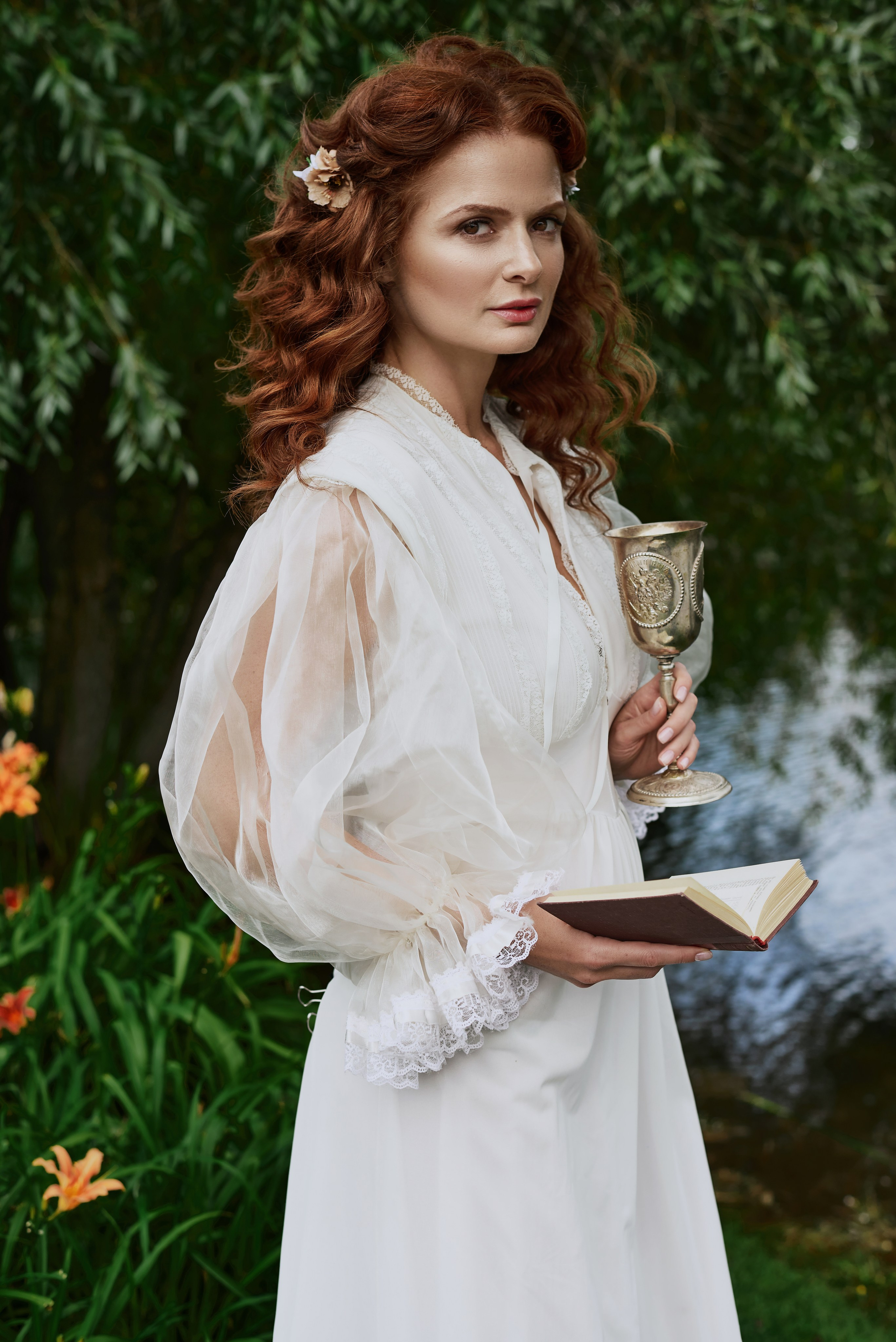 Фотопортрет Елены Ландер в белом платье с книжкой и серебряным кубком
