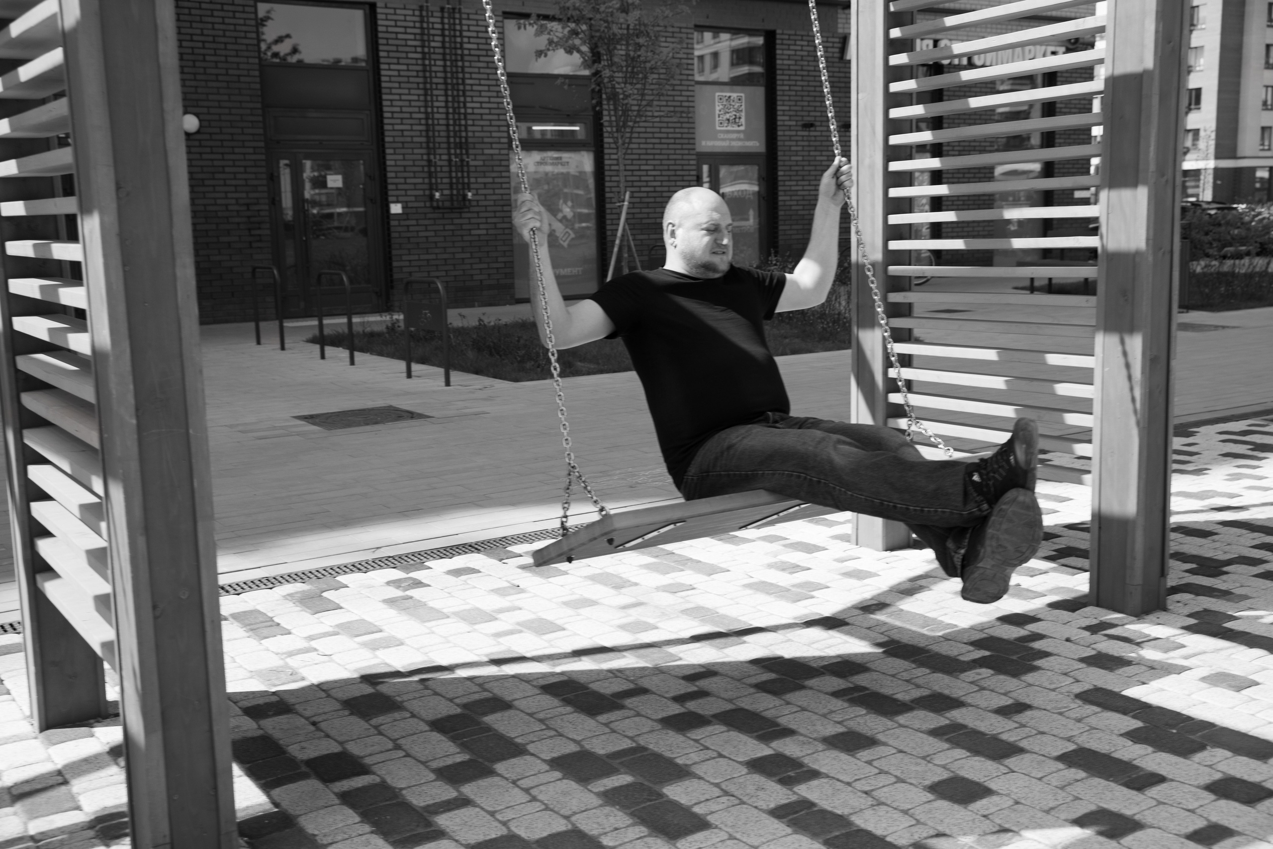 мужской портрет уличная фотосессия, качается на качелях 