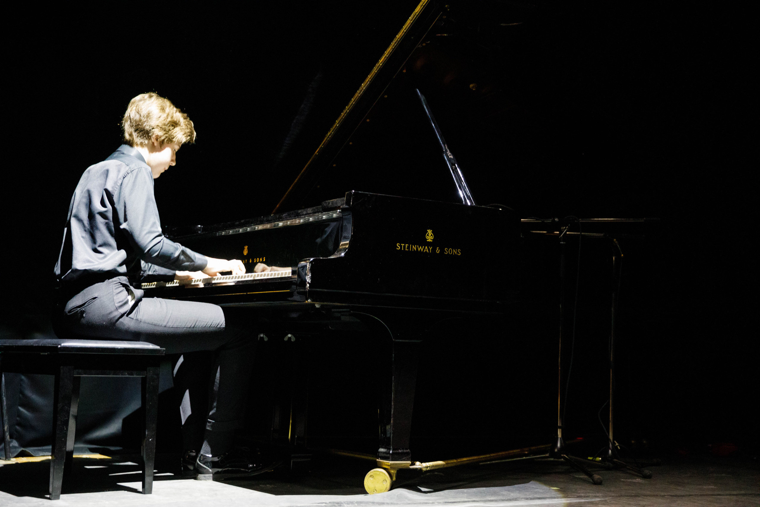 Пианист за роялем на сцене