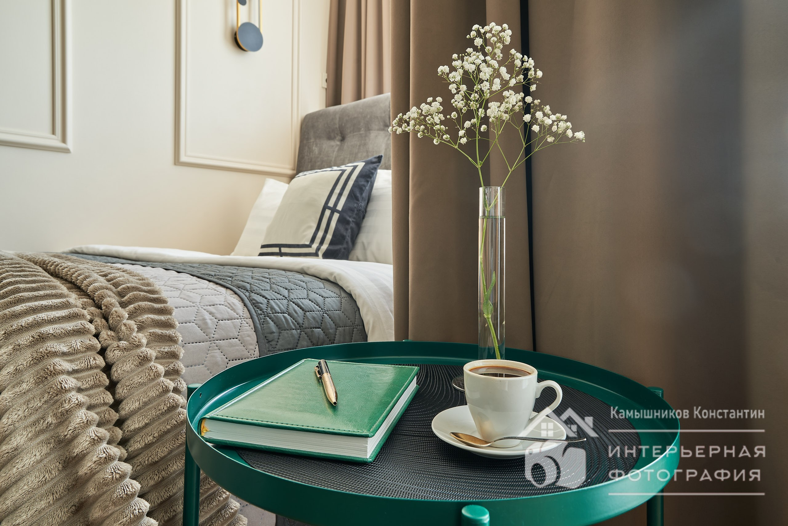 Интерьерное фото апартаментом с крупным планом стильного прикроватного столика с чашечкой кофе